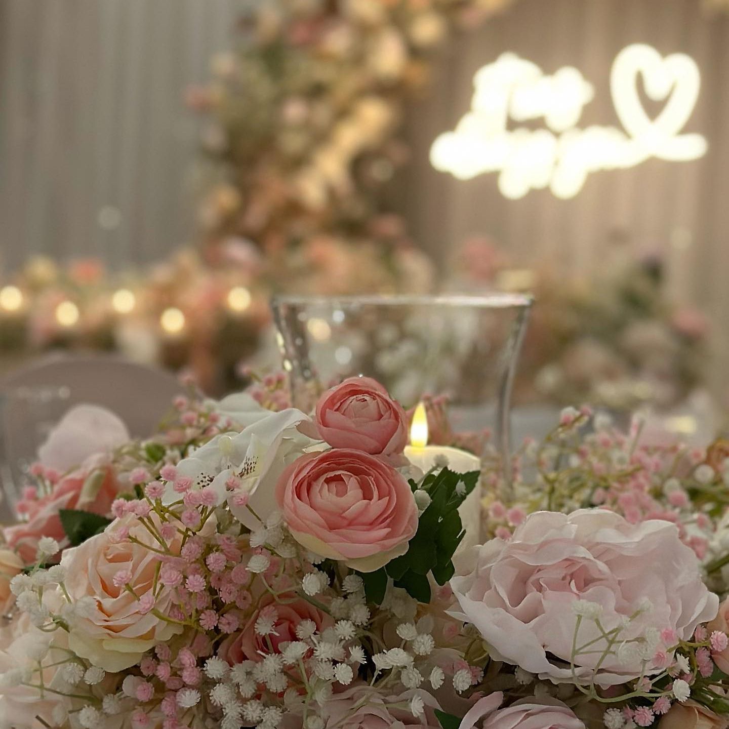 Close-up of a floral arrangement with pink and white roses at a wedding or romantic event.
