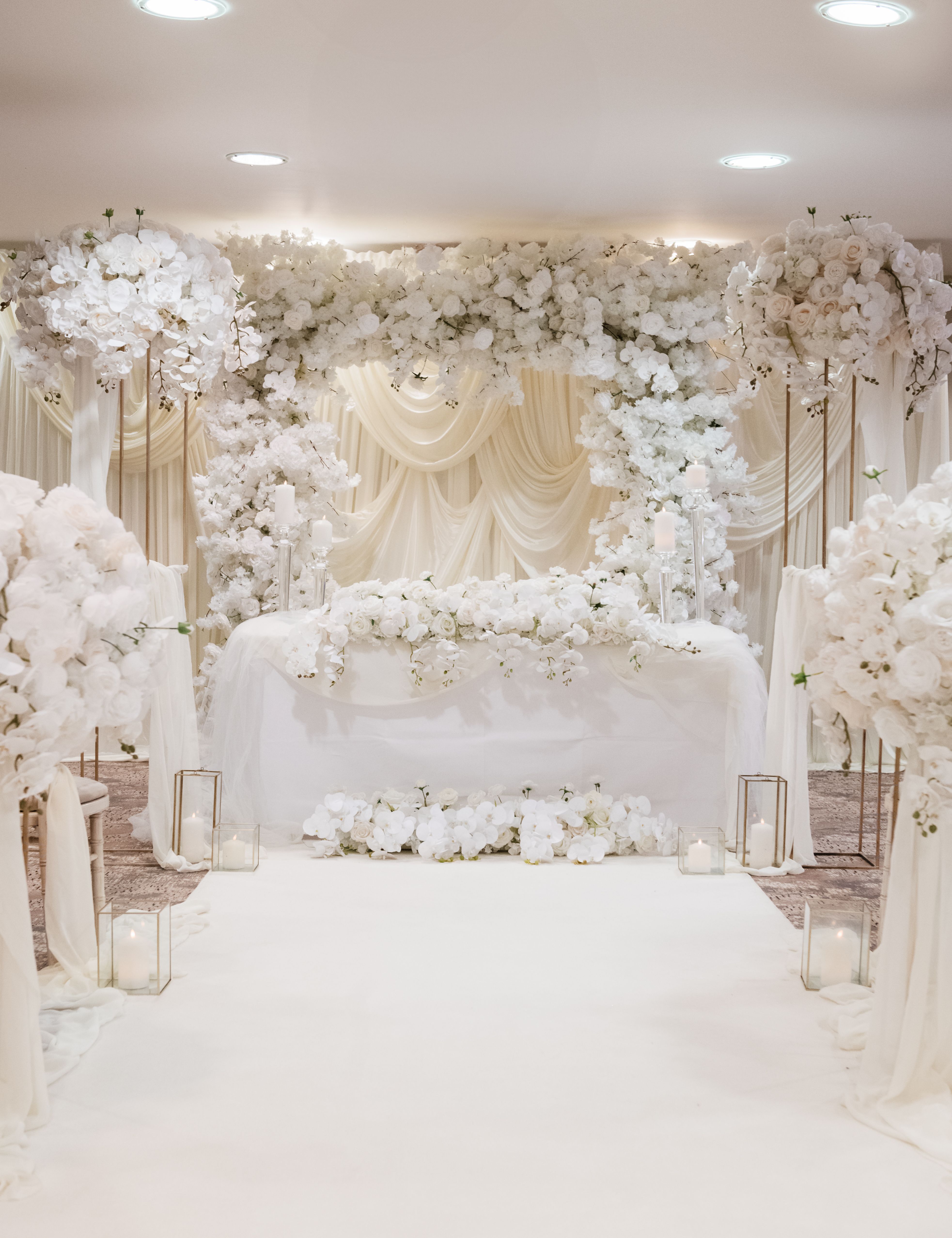 Luxurious wedding altar decorated with white flowers and draped fabric