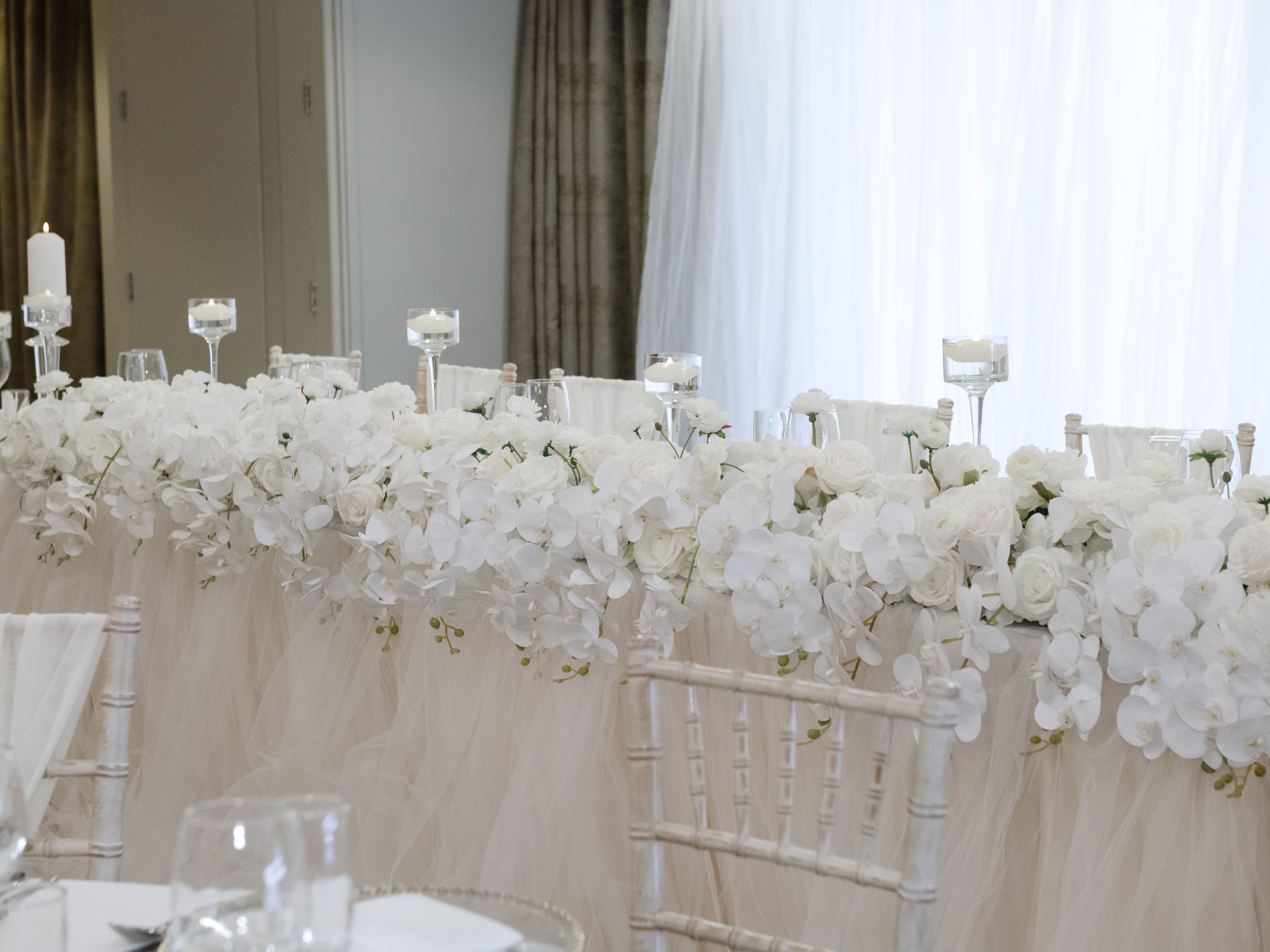 Elegant wedding table decorated with white flowers and candles