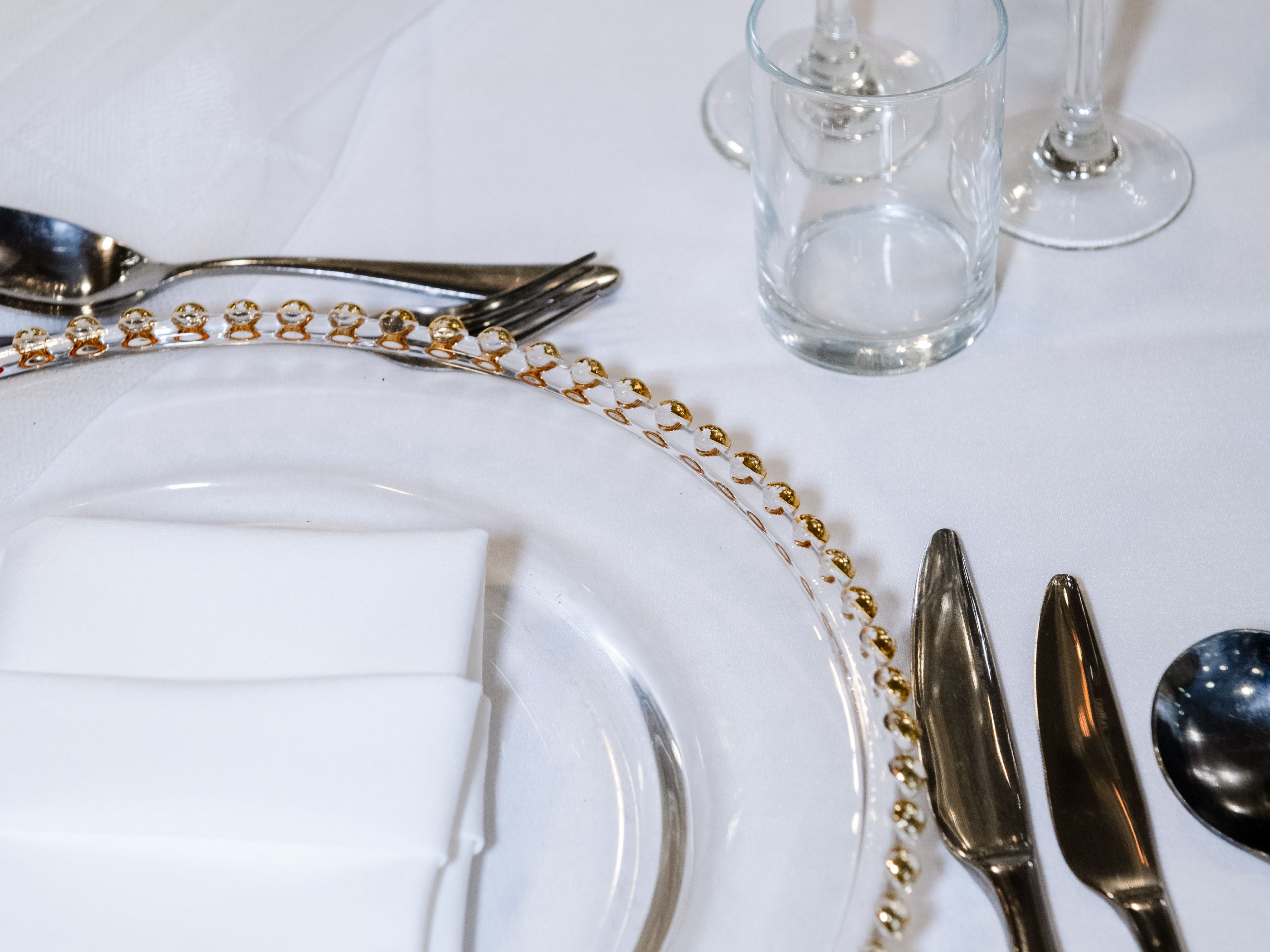 Elegant table setting with glassware, cutlery, and a decorative plate