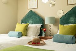 two single beds with beautiful green headboards