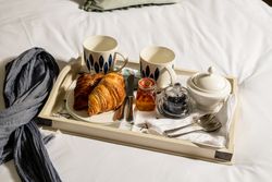 tray of croissants and tea in bed