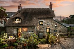 outside of ring and thimble cottage with thatched roof