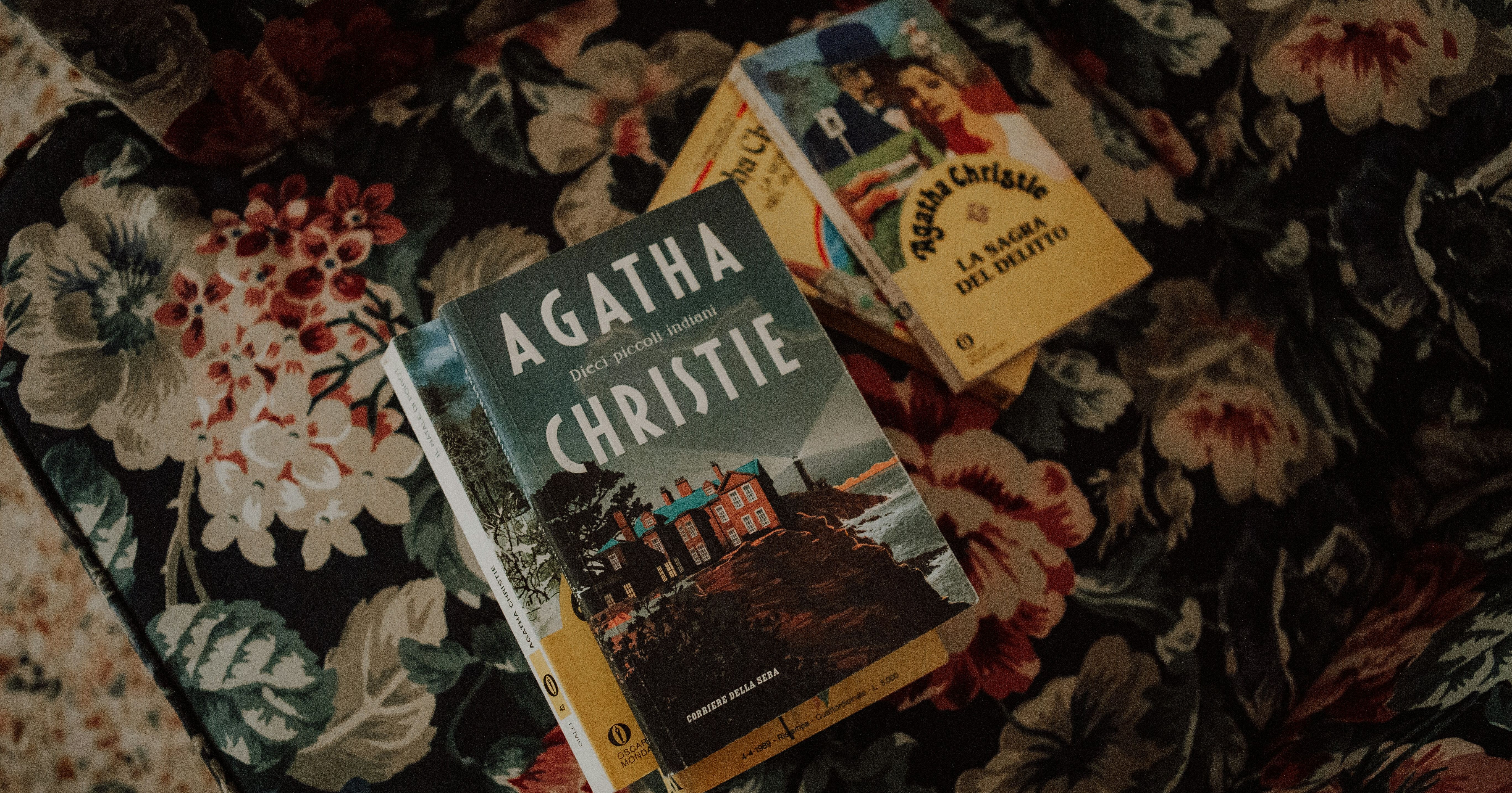 Three Agatha Christie books on a floral upholstered surface