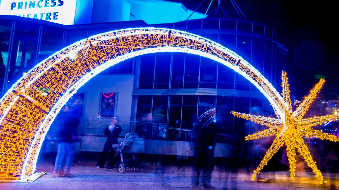 Illuminated arch and star light installation outside Princess Theatre at night.