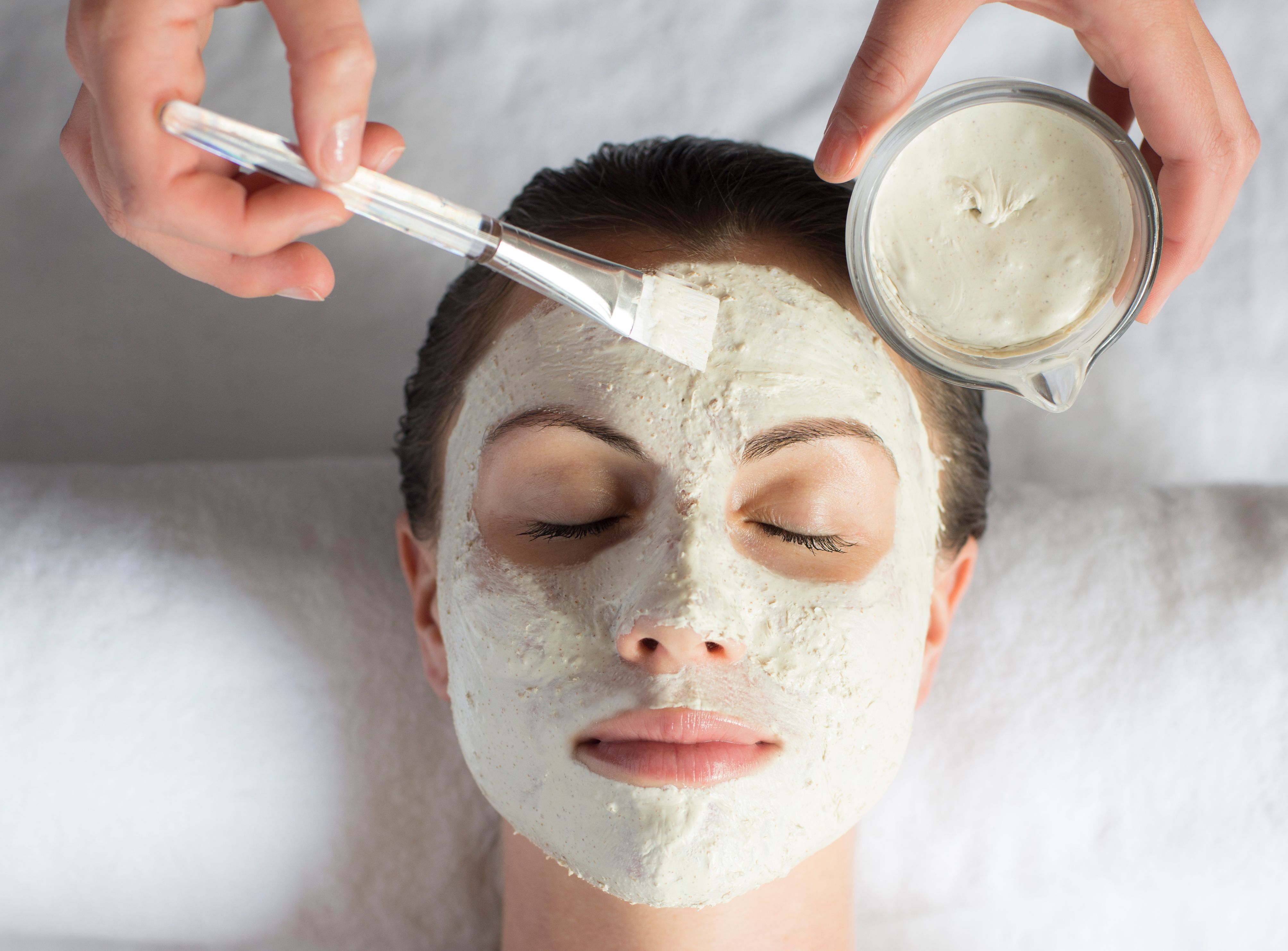 Person receiving a facial mask treatment at a spa