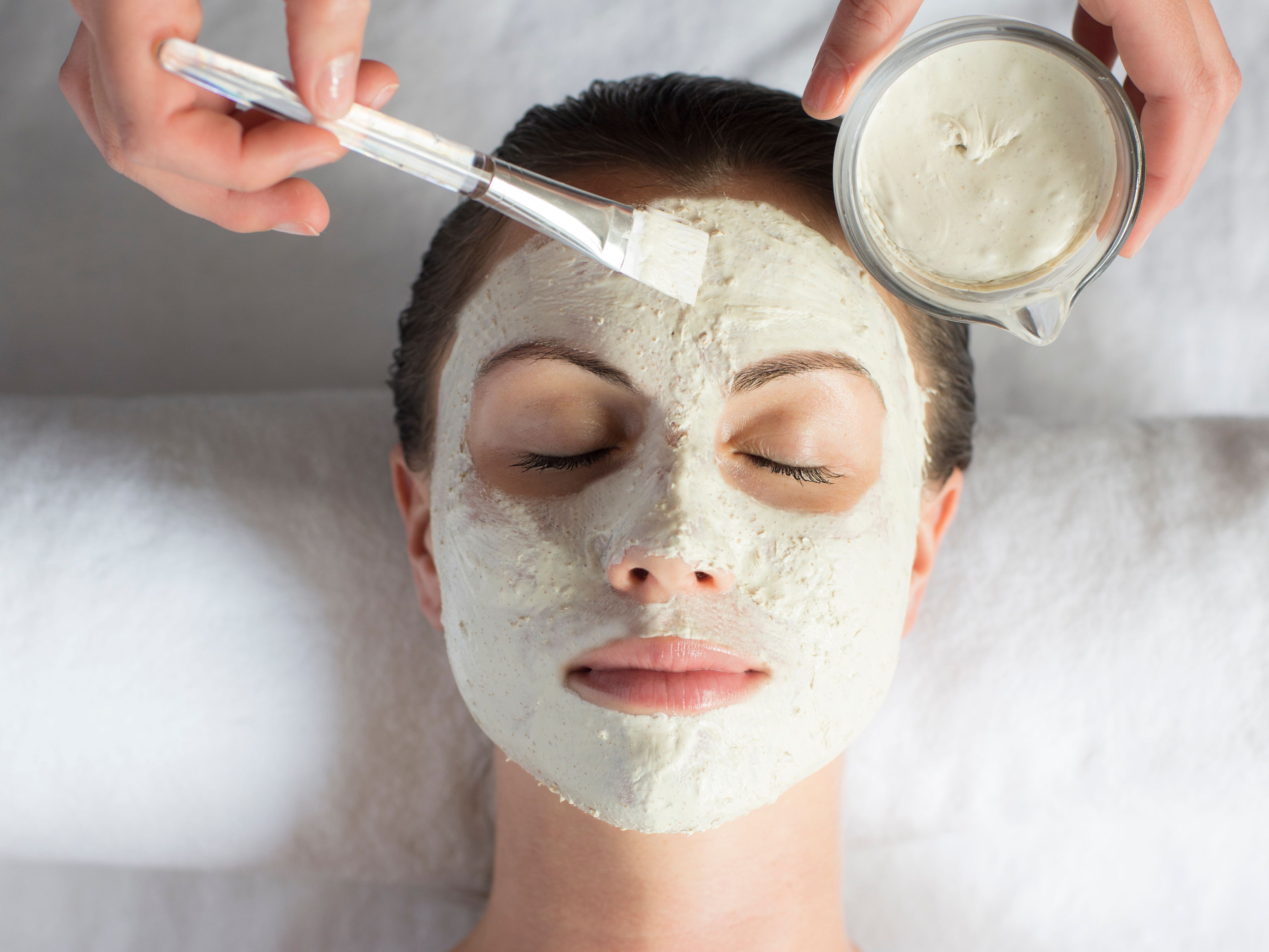 Person receiving a facial mask treatment at a spa