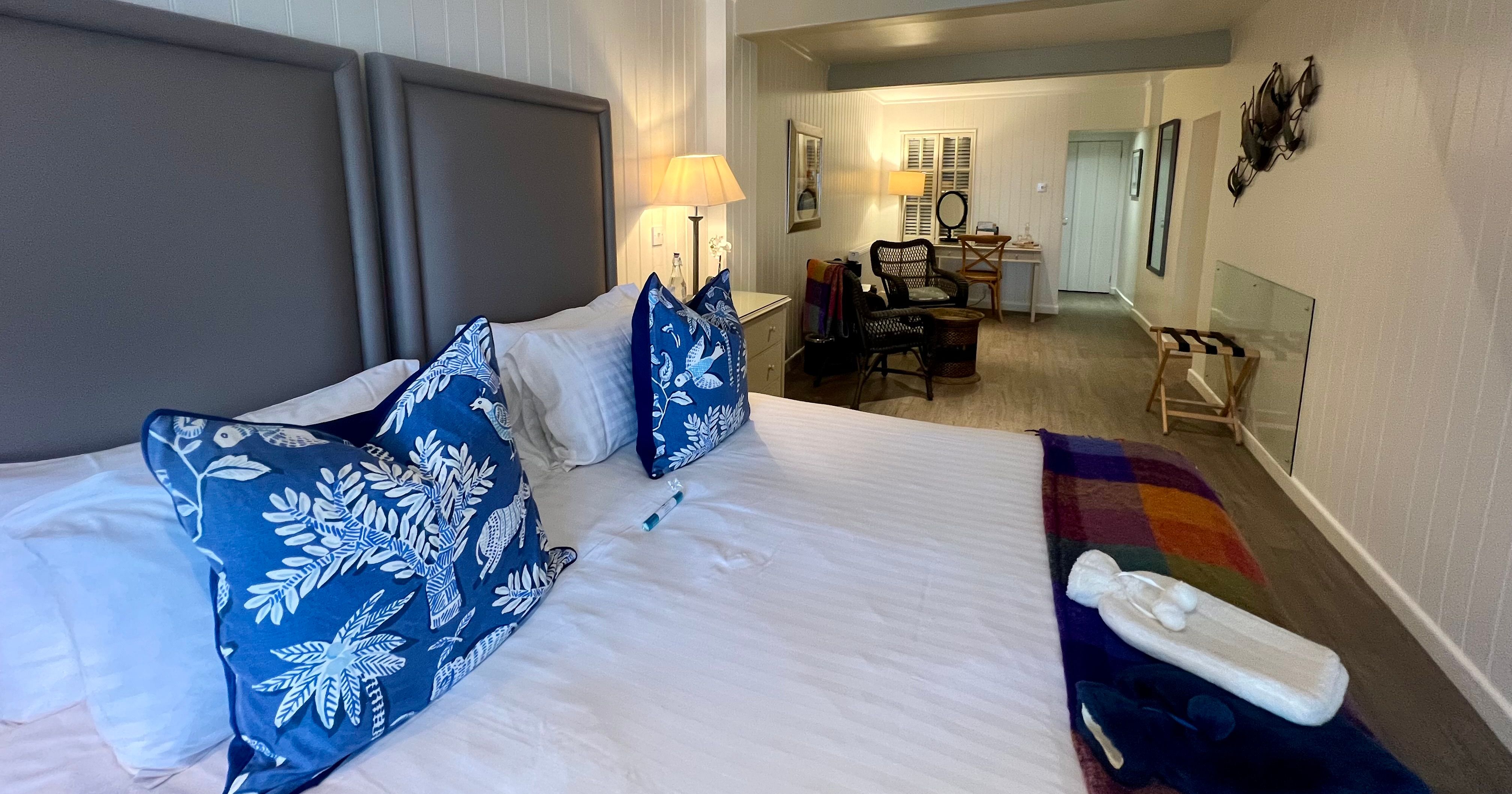 Cosy hotel room with a double bed, blue patterned cushions and a desk area