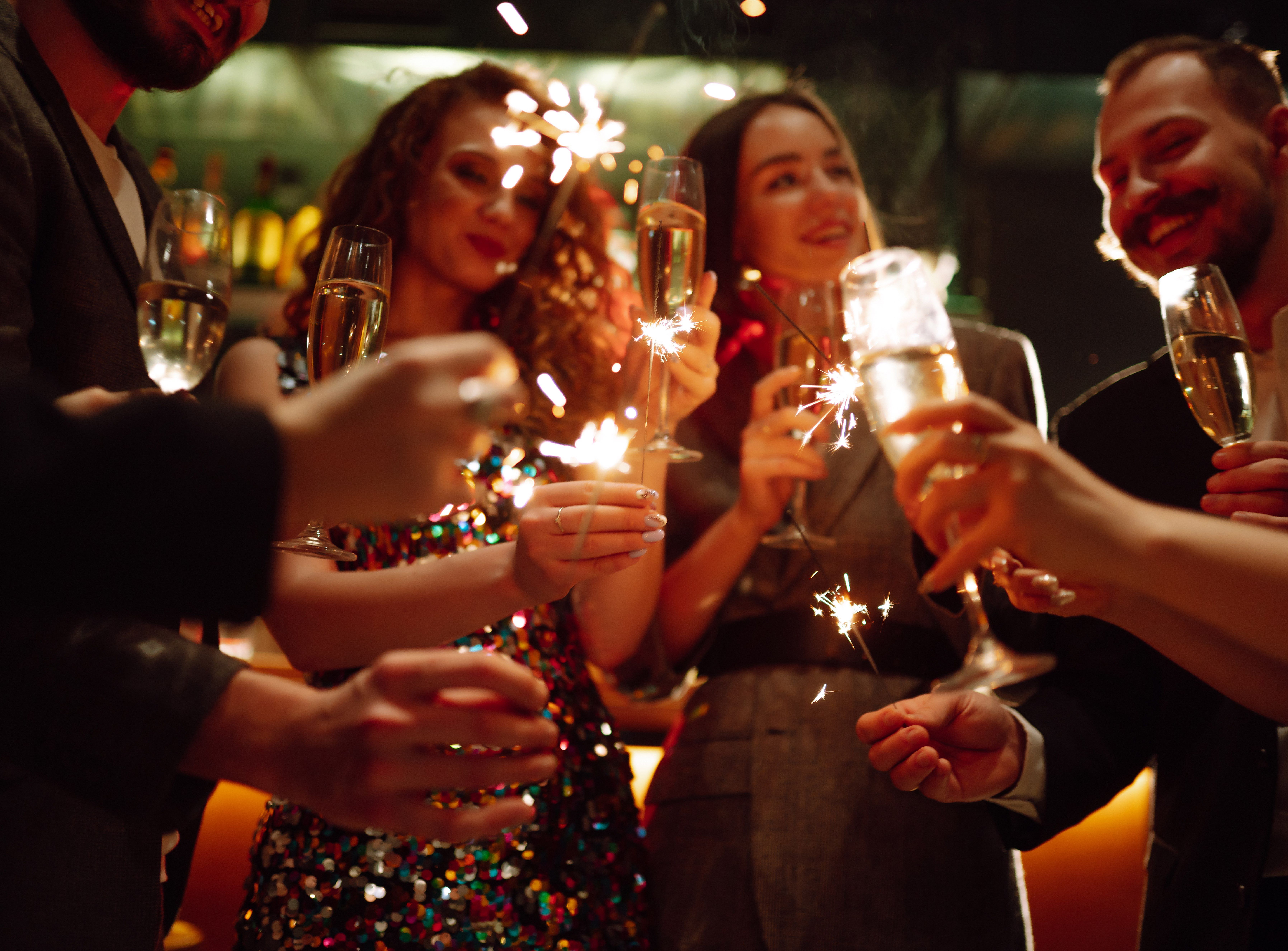 Friends celebrating with sparklers and glasses of champagne at a party