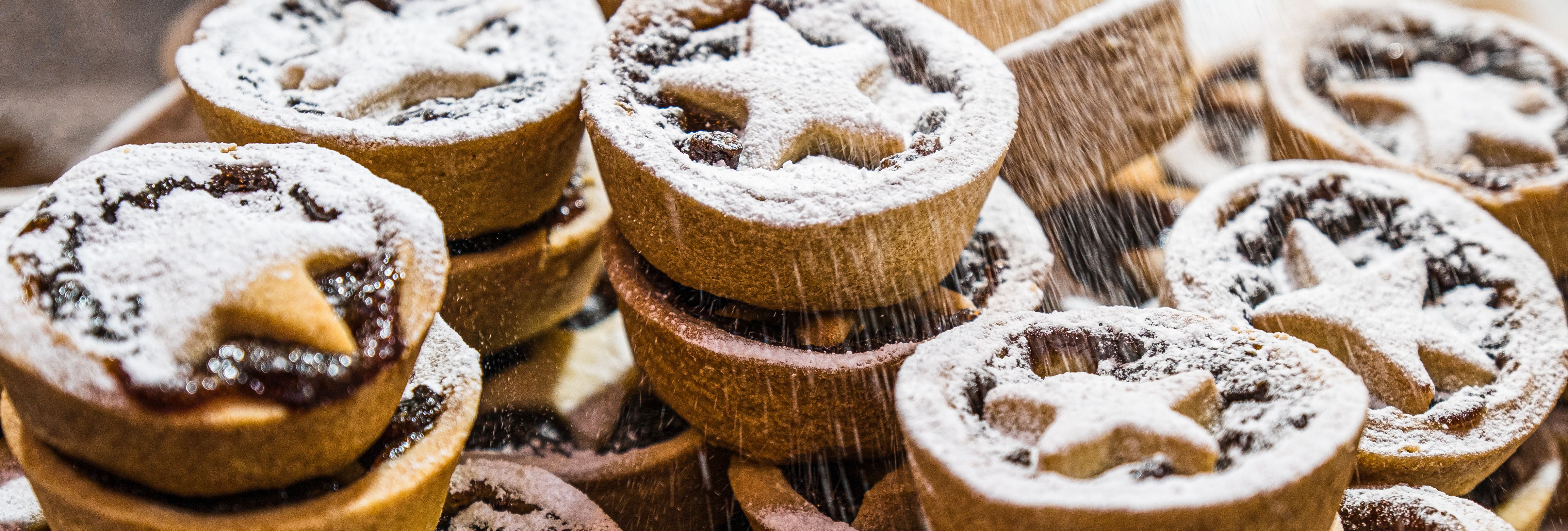 Stack of mince pies dusted with icing sugar