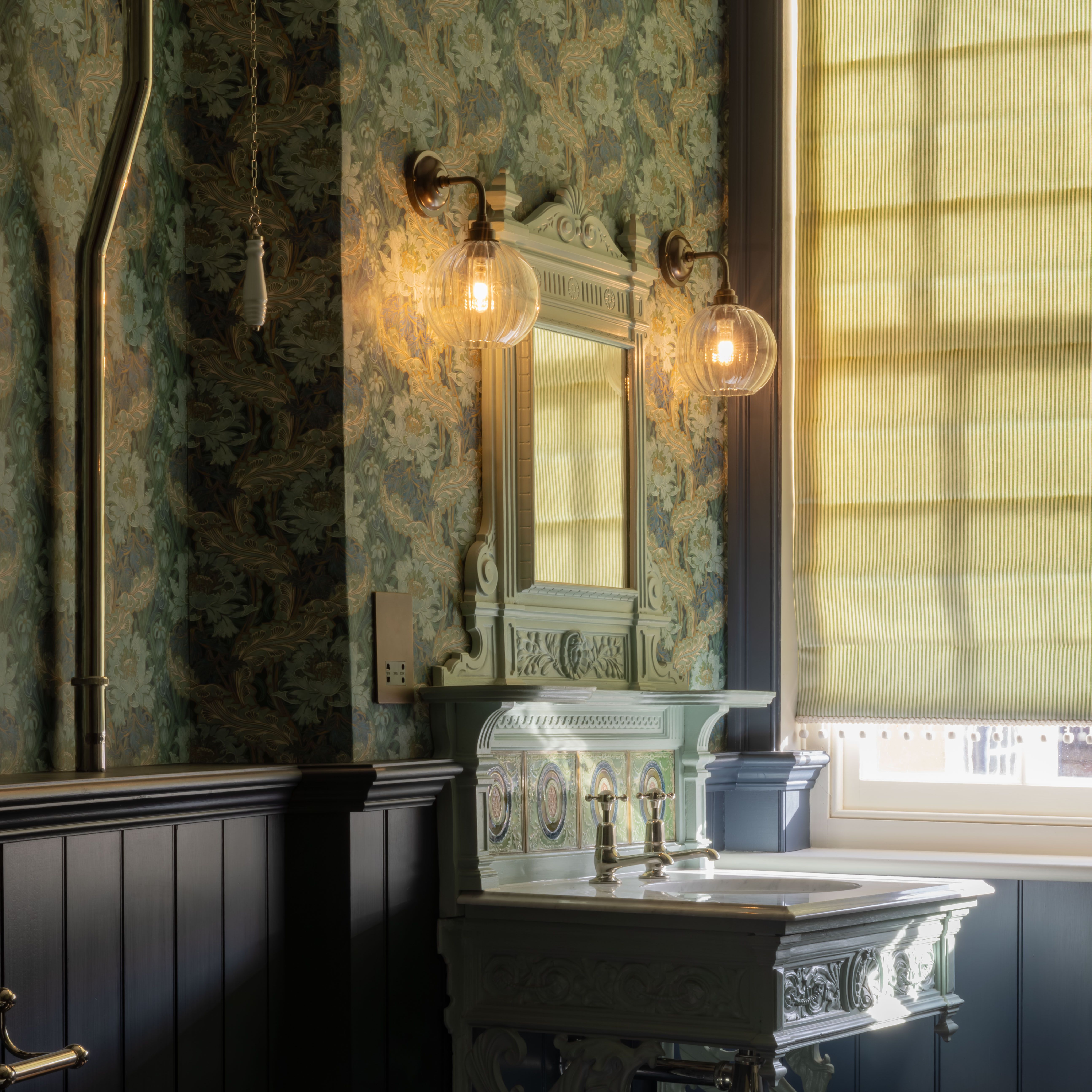 Victorian-style bathroom with ornate sink, clawfoot tub, and floral wallpaper