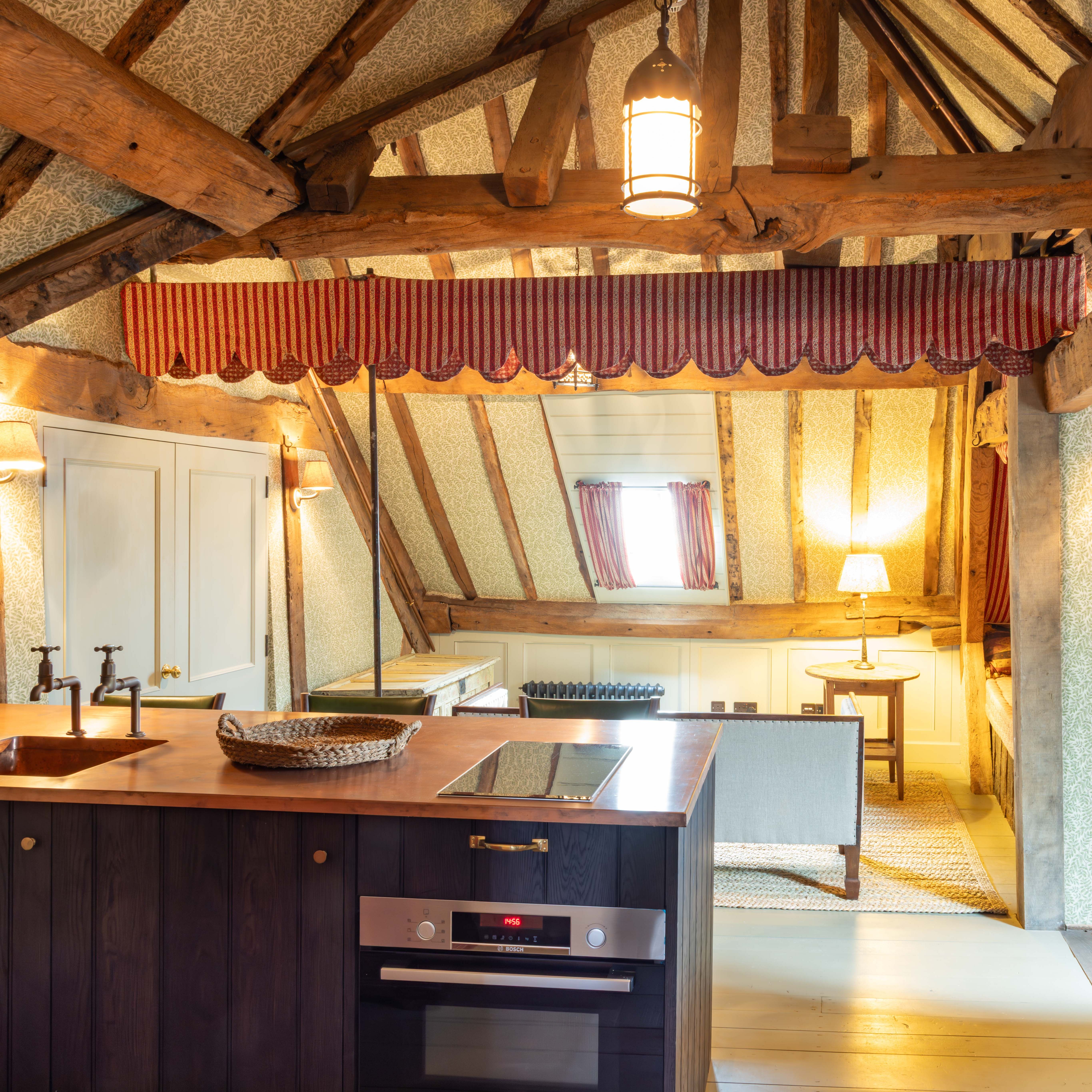 Rustic attic kitchen with exposed wooden beams and modern amenities