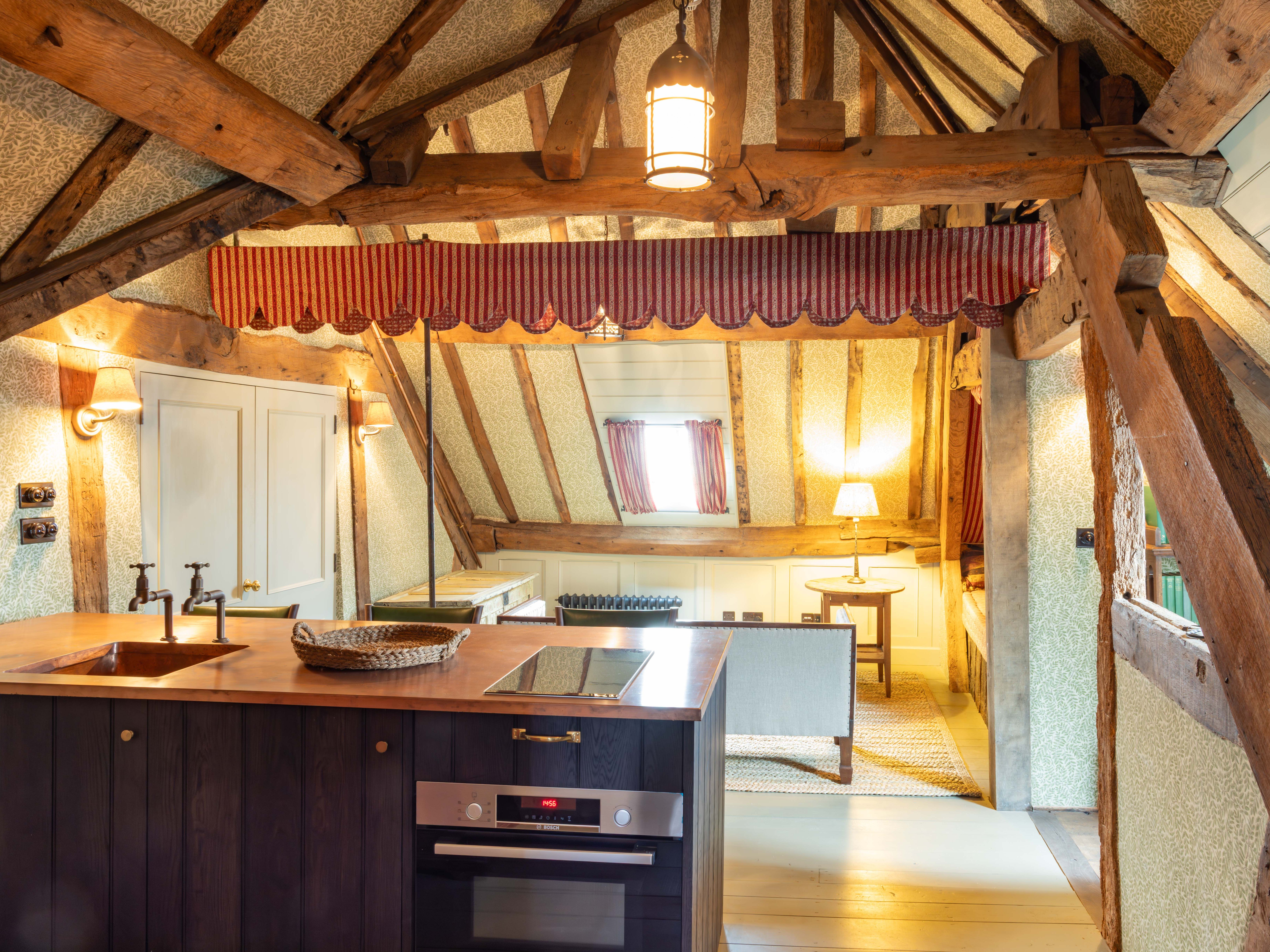 Rustic attic kitchen with exposed wooden beams and modern amenities