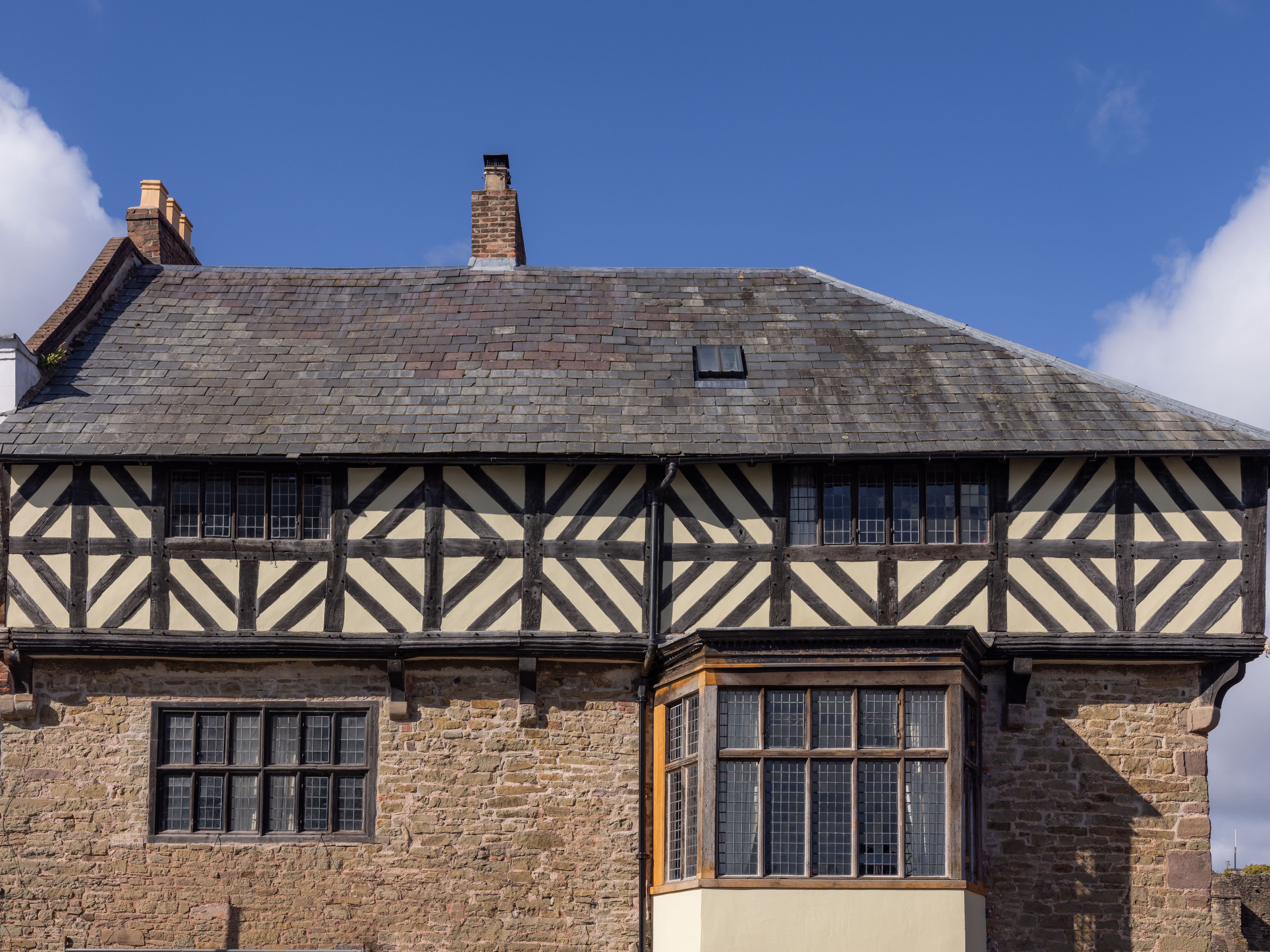 Historic half-timbered house with stone lower level and large windows