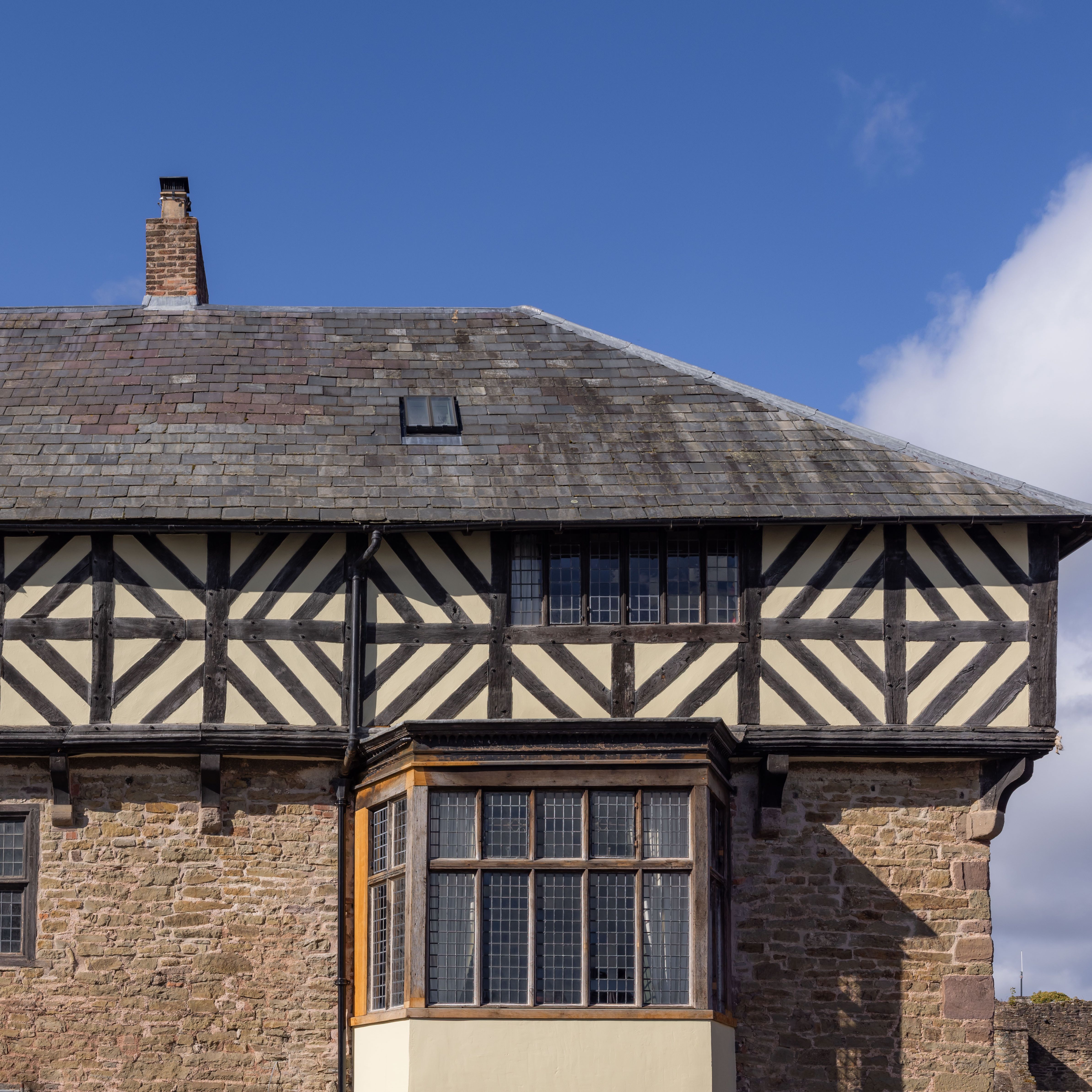 Historic half-timbered house with stone lower level and large windows