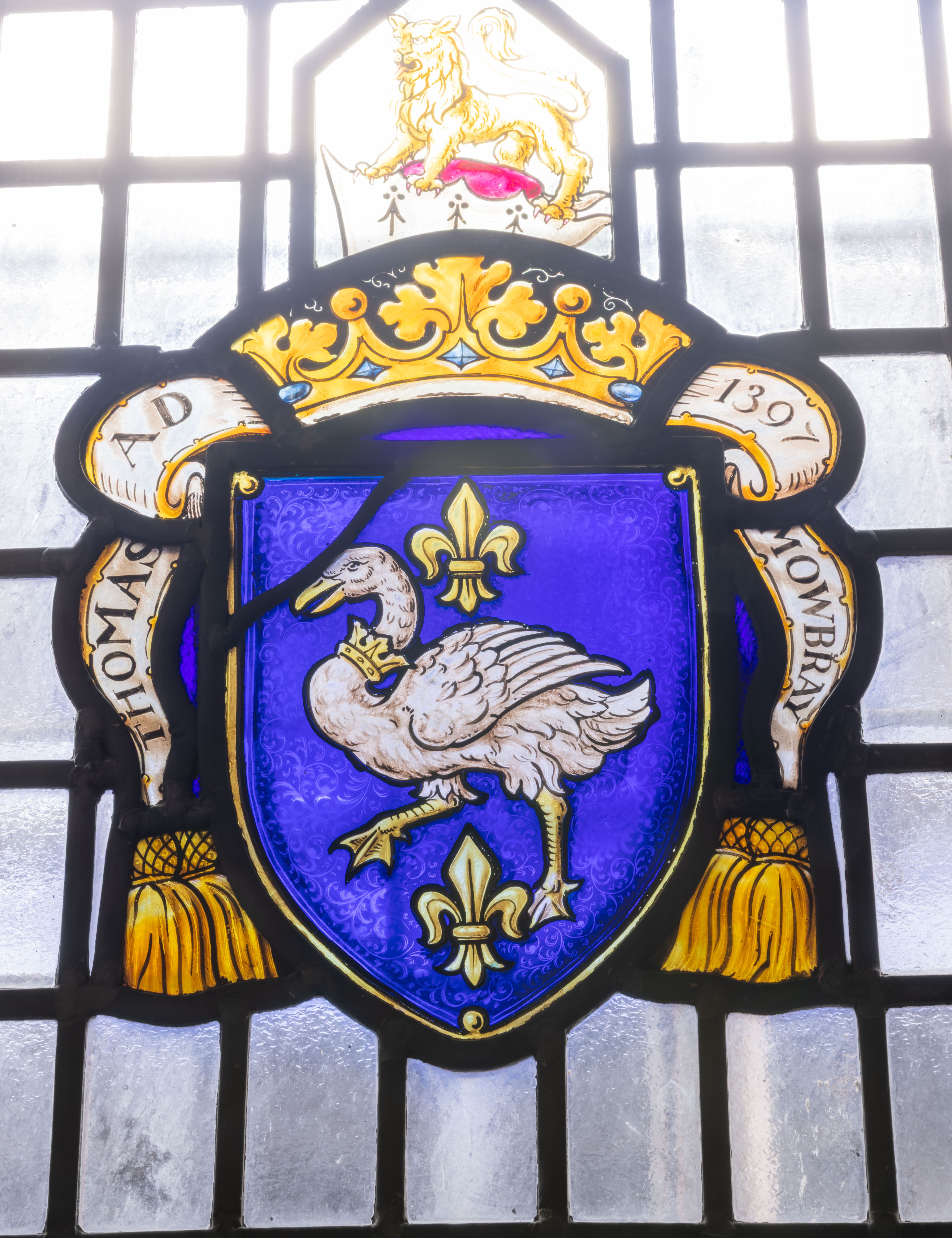Stained glass window with a heraldic crest featuring a crowned white swan and fleur-de-lis