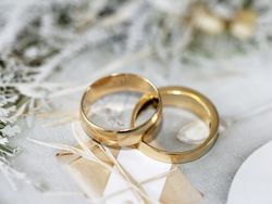 Two gold wedding rings placed on a decorative surface