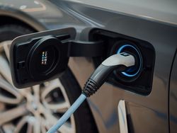 Electric car being charged with a charging cable plugged in