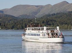 Passenger ferry boat cruising on a lake with hills in the background