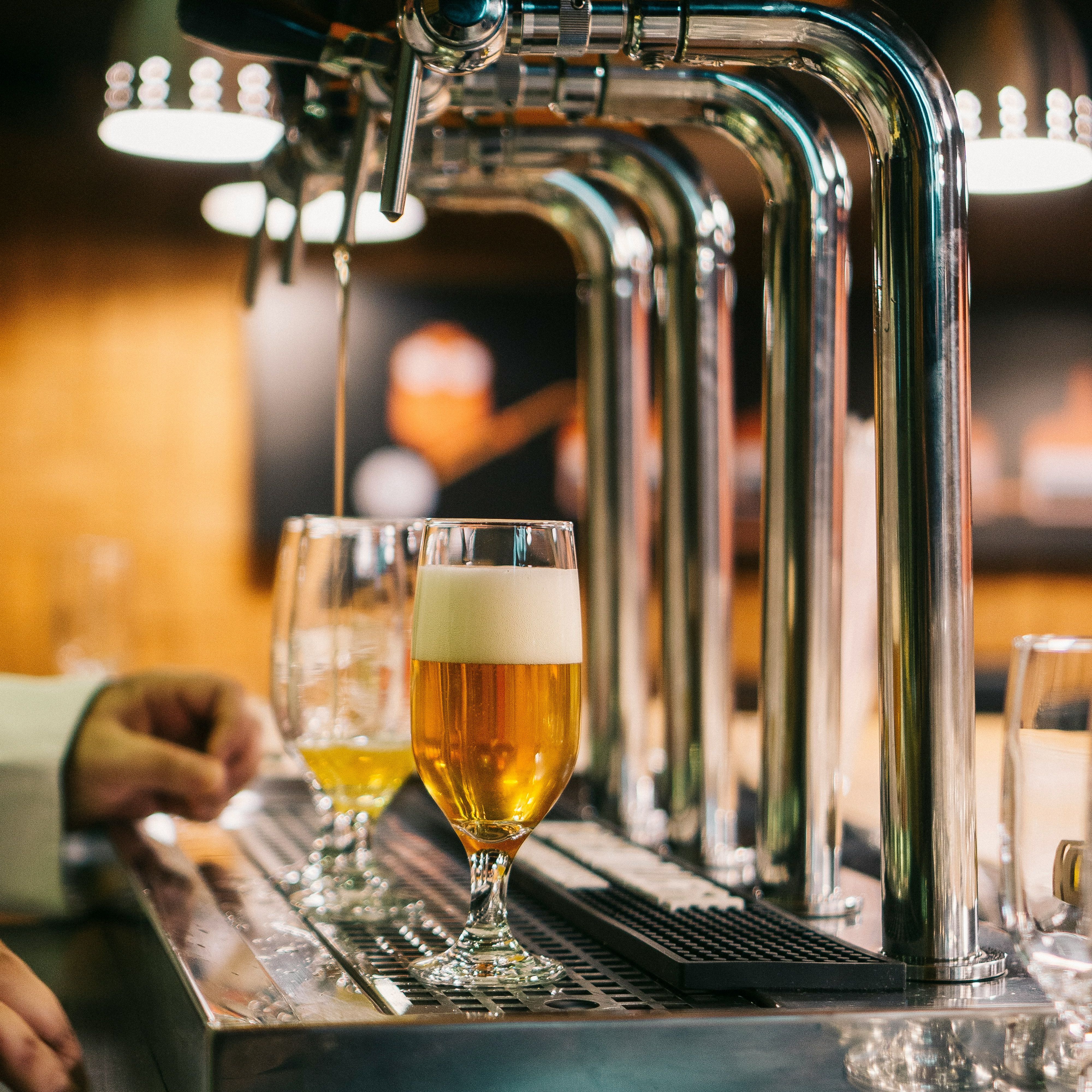 Close-up of beer taps pouring draft beer into glasses at a bar