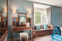 Elegant room with wooden vanity, window seat, and blue accents