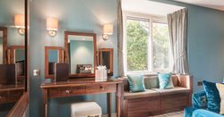Elegant room with wooden vanity, window seat, and blue accents