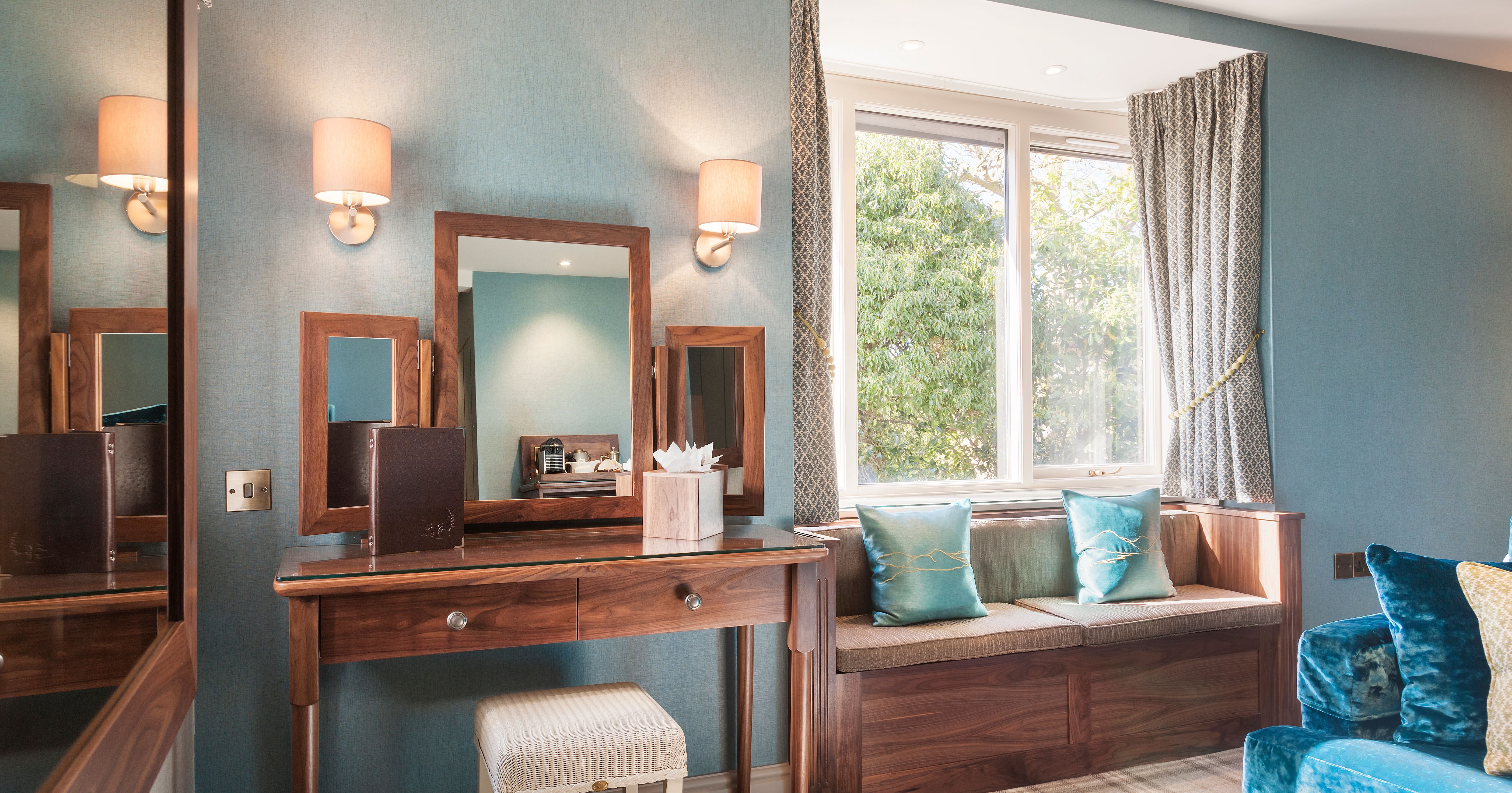 Elegant room with wooden vanity, window seat, and blue accents