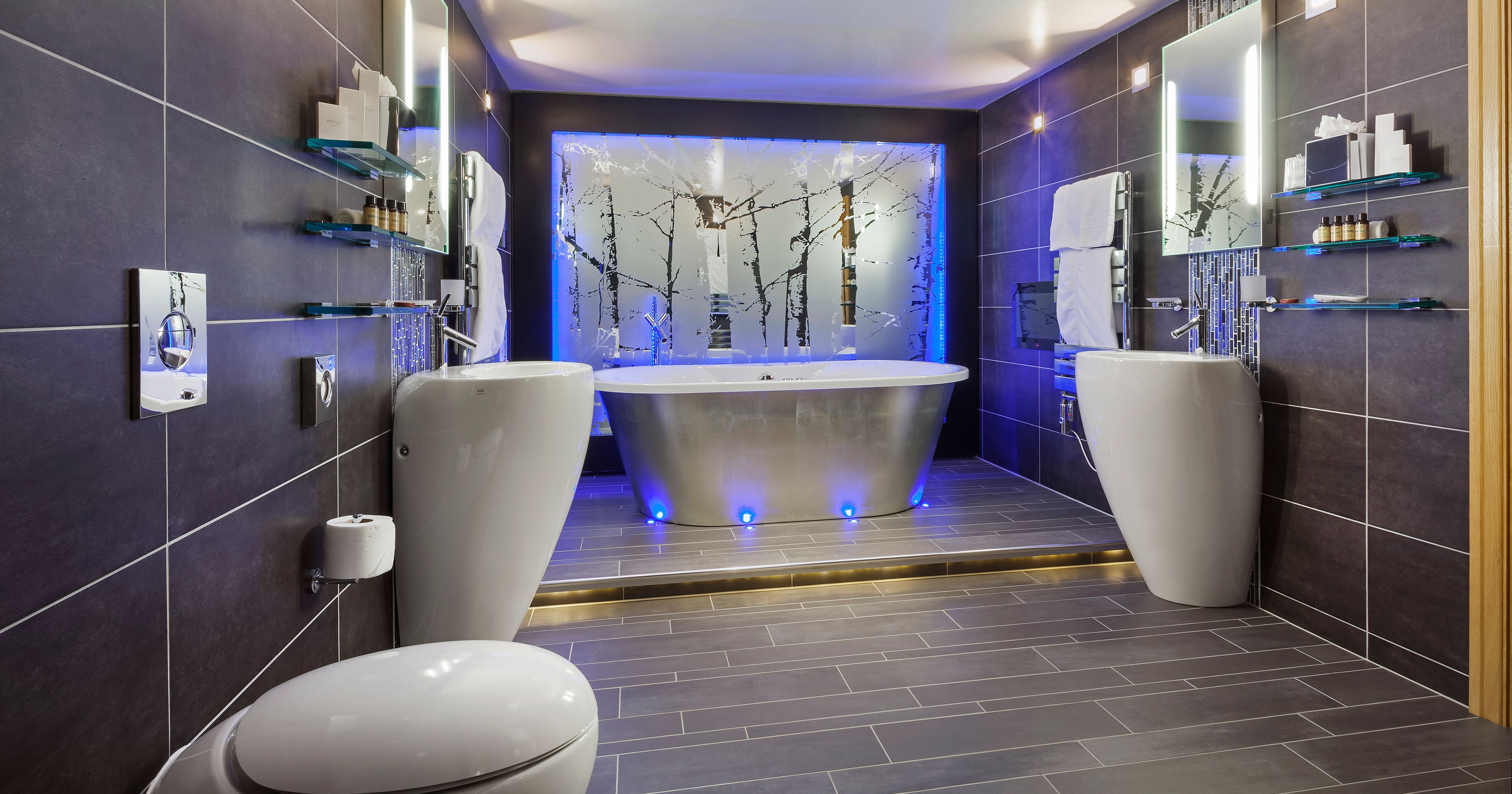 Luxury modern ensuite bathroom with a freestanding bathtub and ambient blue lighting