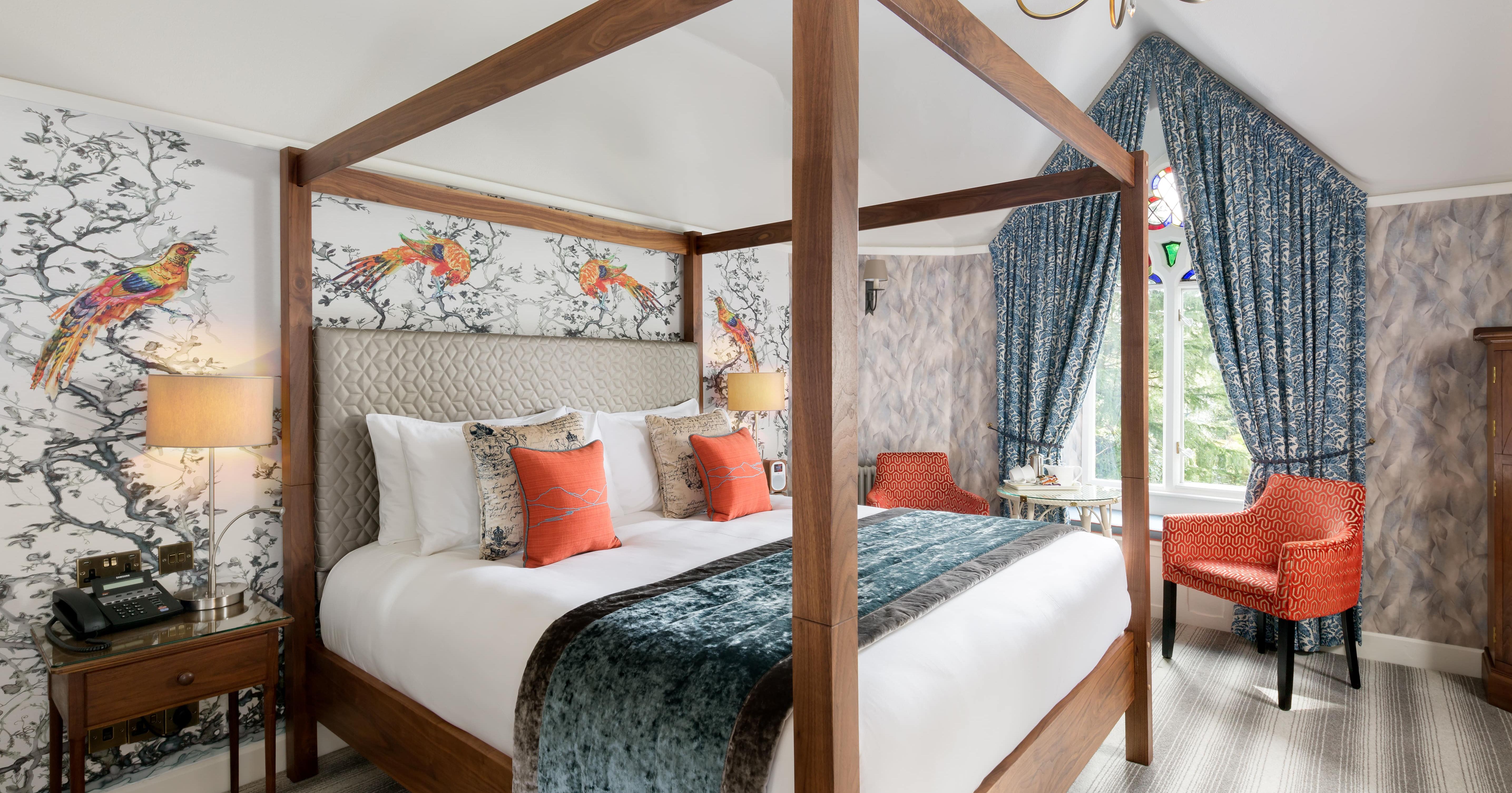 Elegant bedroom with a four-poster bed, decorative wallpaper, and vibrant accents