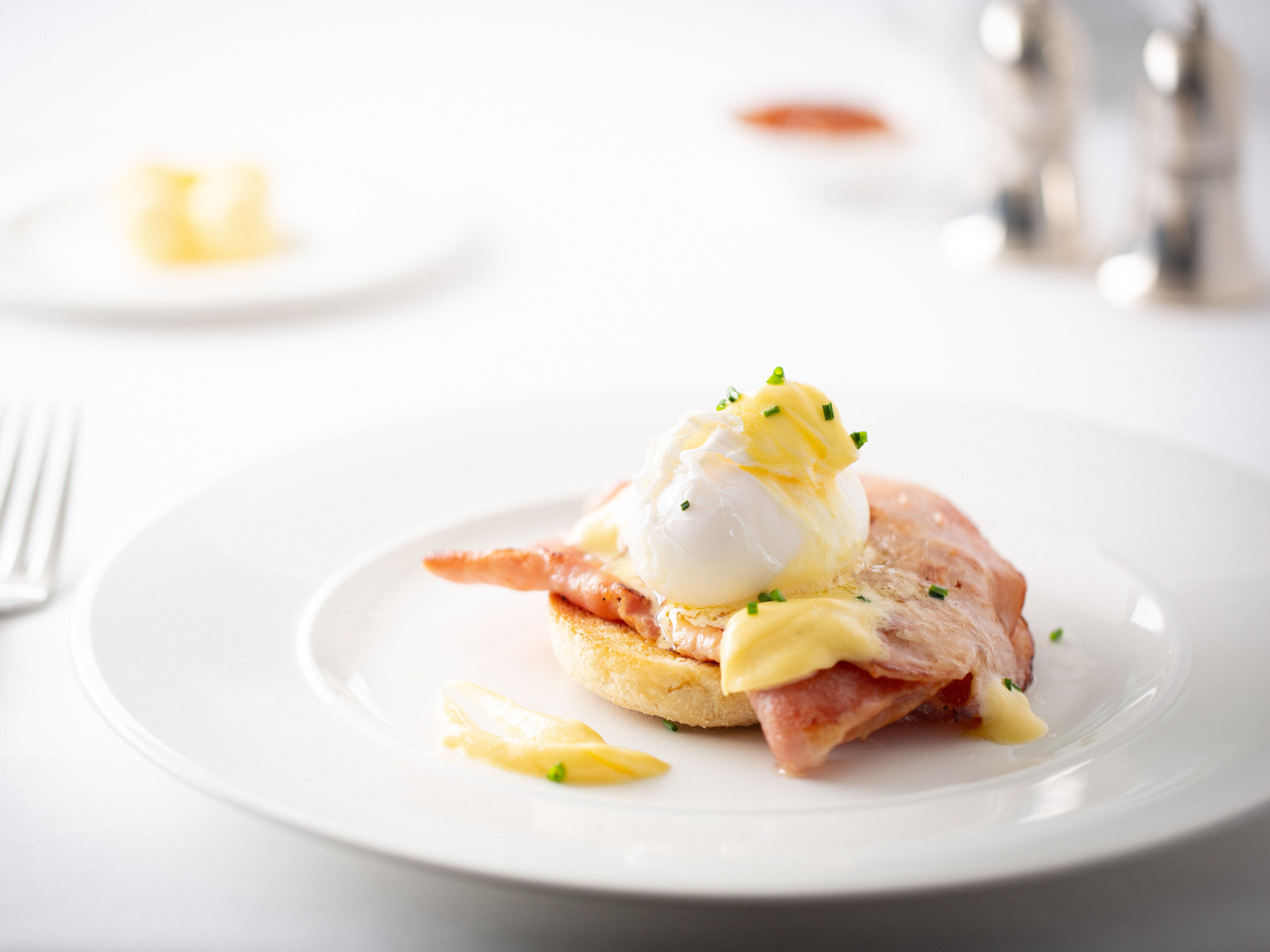 Eggs Benedict with ham and hollandaise sauce on an English muffin