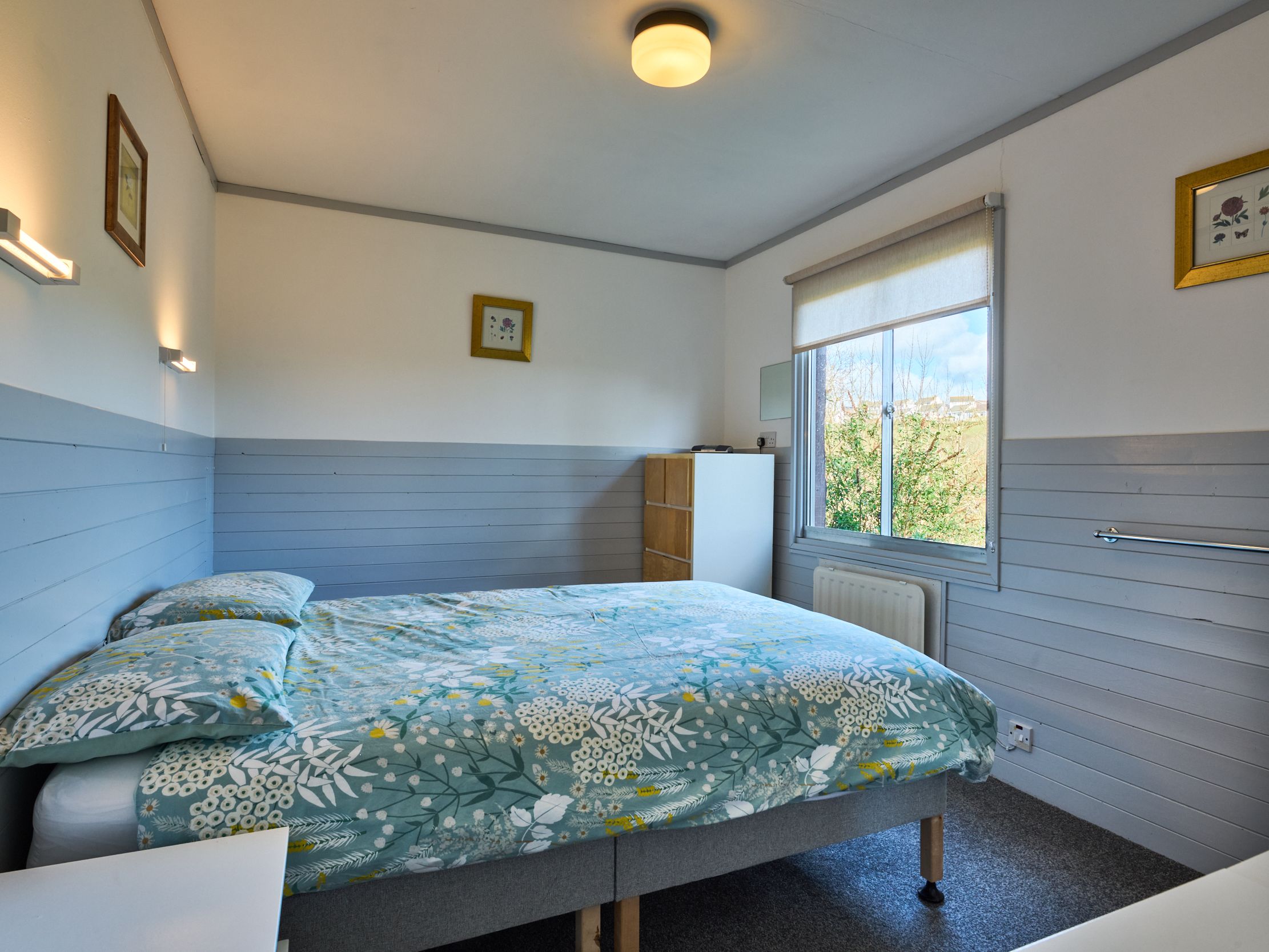 Bright bedroom with floral bedding and large window