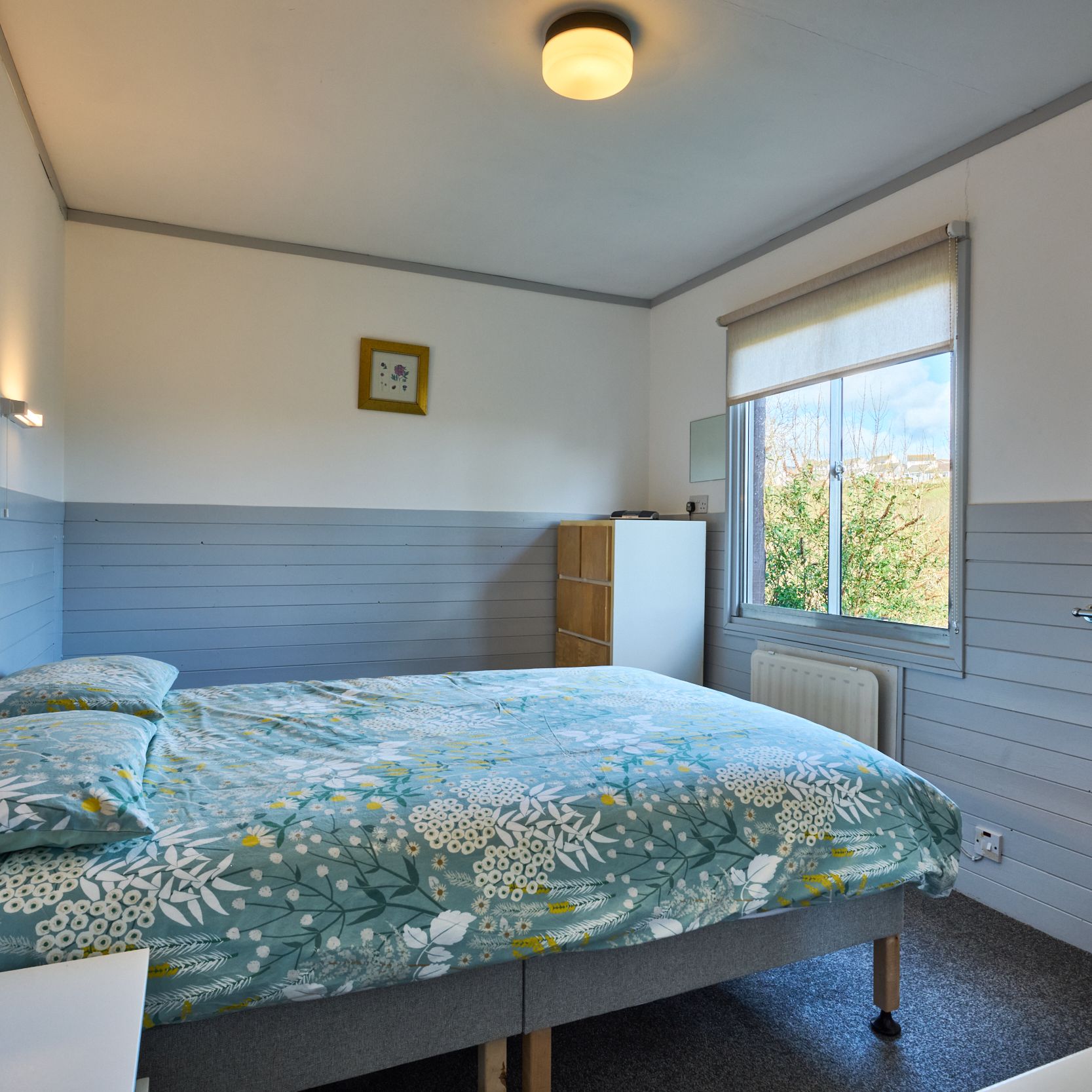 Bright bedroom with floral bedding and large window