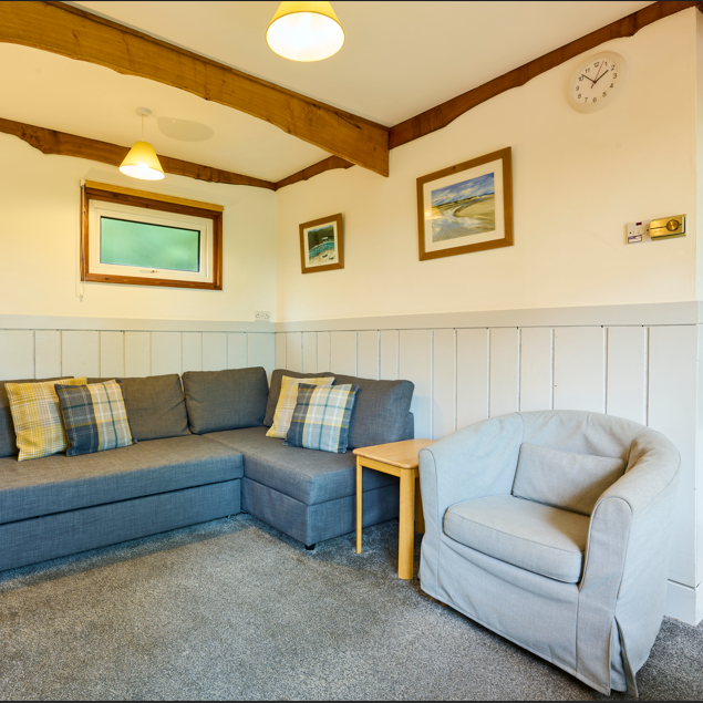 Cozy living room with gray sofa, armchair, and wooden side tables.