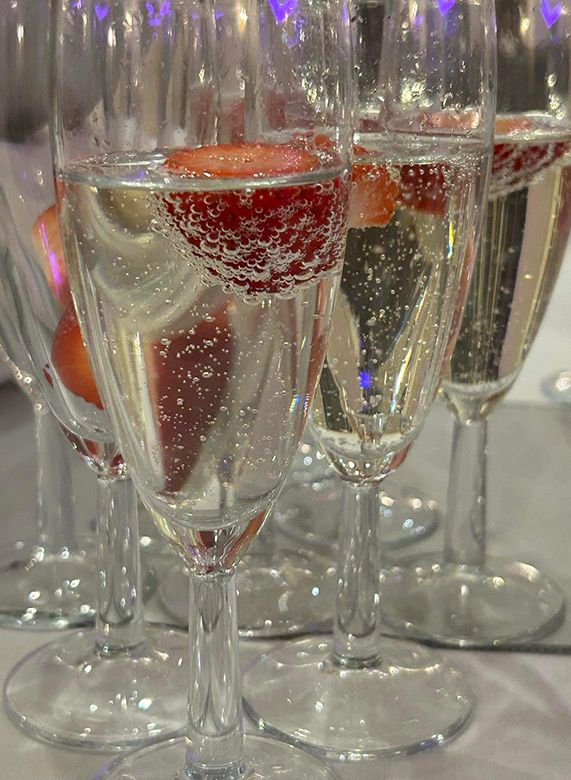 Champagne flutes with sparkling wine and strawberries on a table