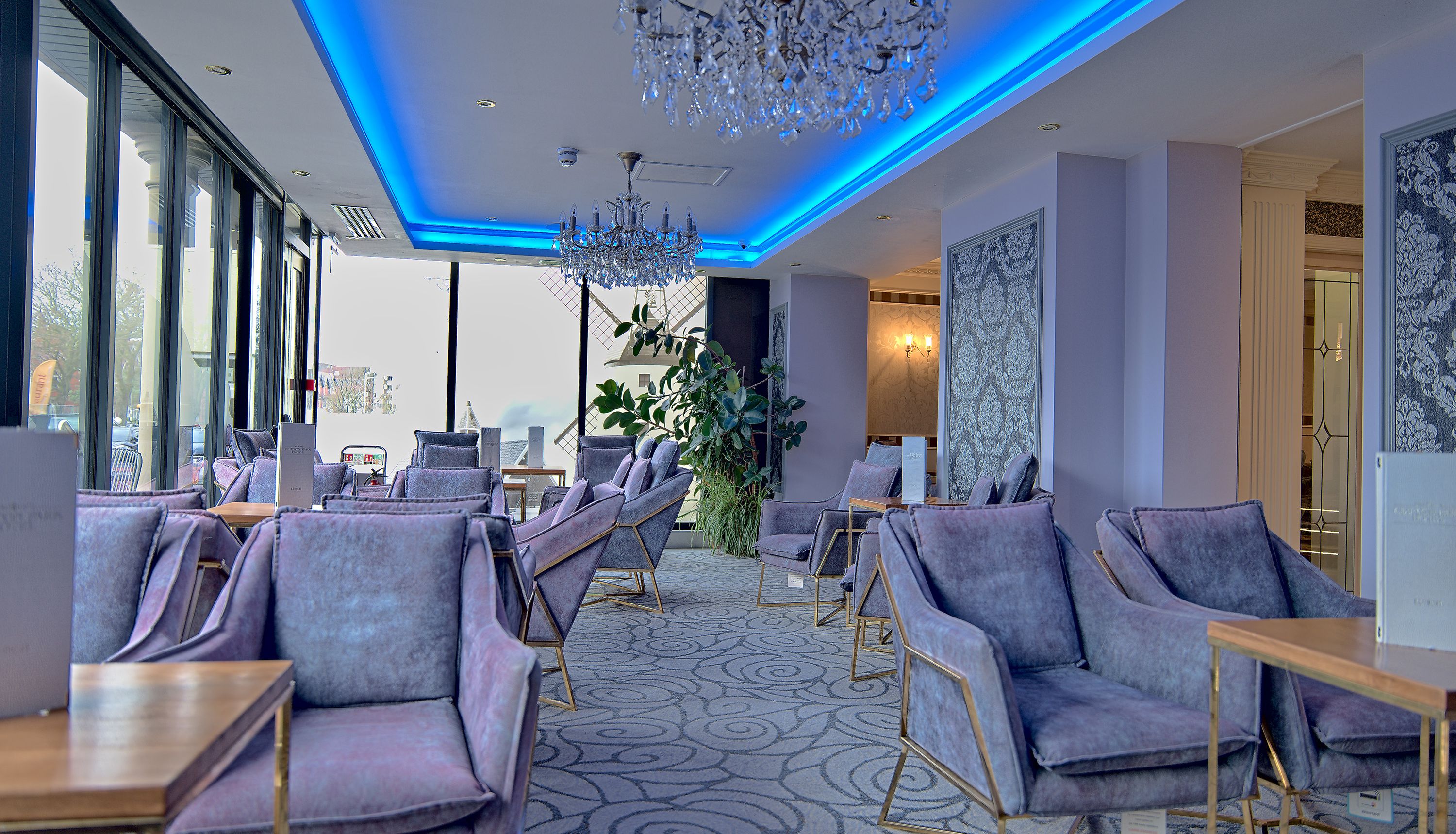 Modern hotel lounge with blue LED ceiling lights and crystal chandeliers
