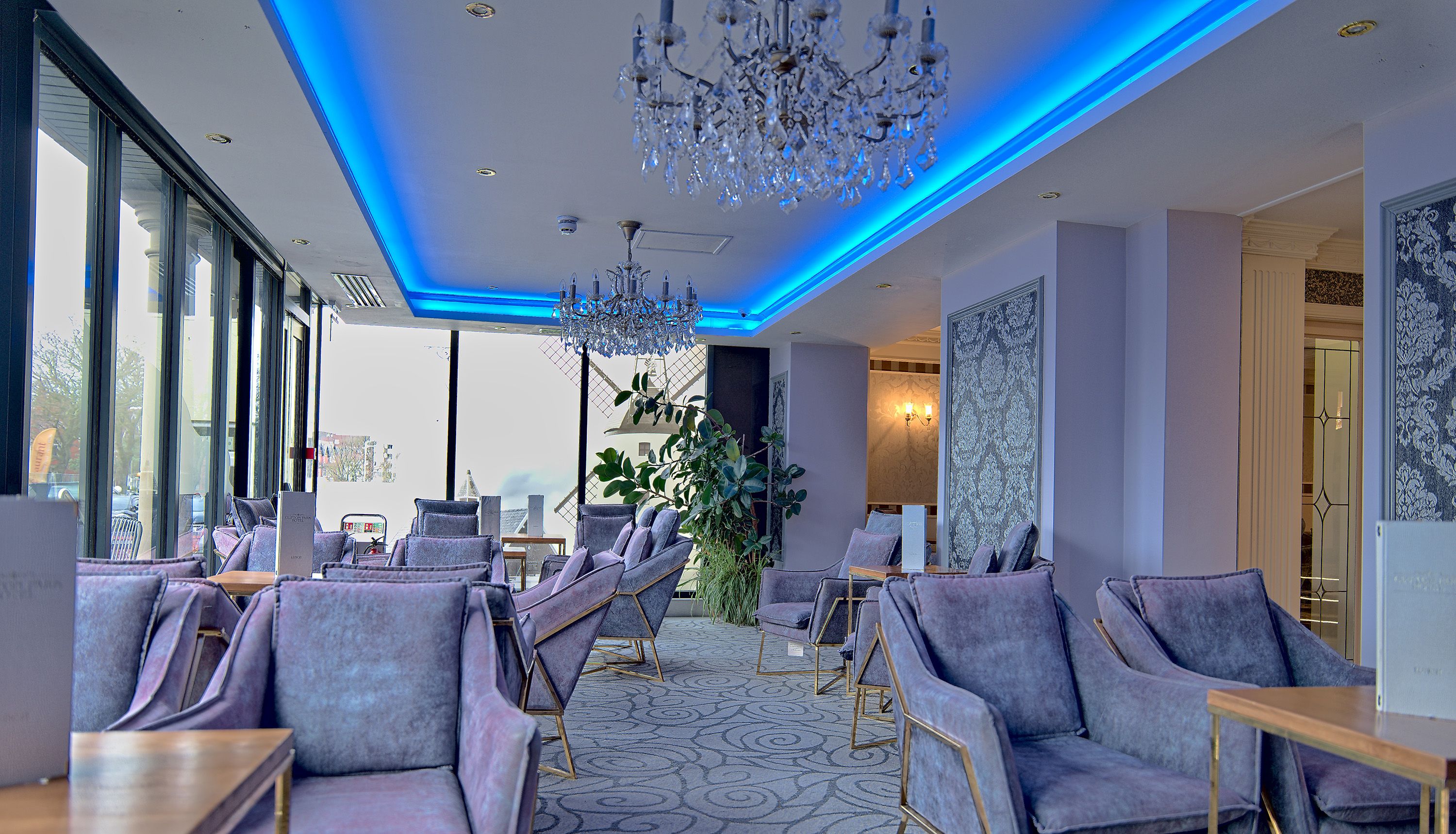 Modern hotel lounge with blue LED ceiling lights and crystal chandeliers