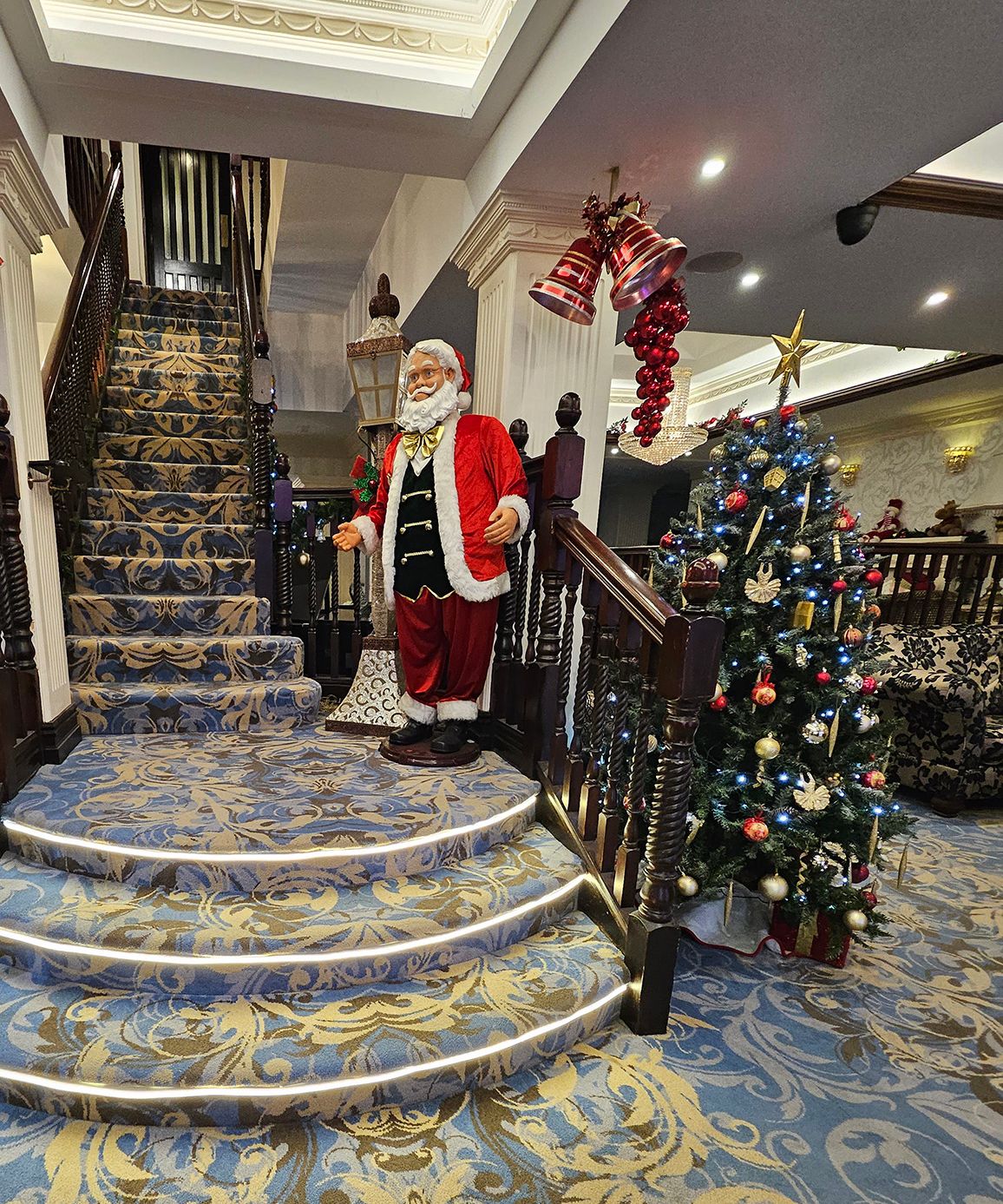 Decorated hotel staircase with Santa figure and Christmas tree