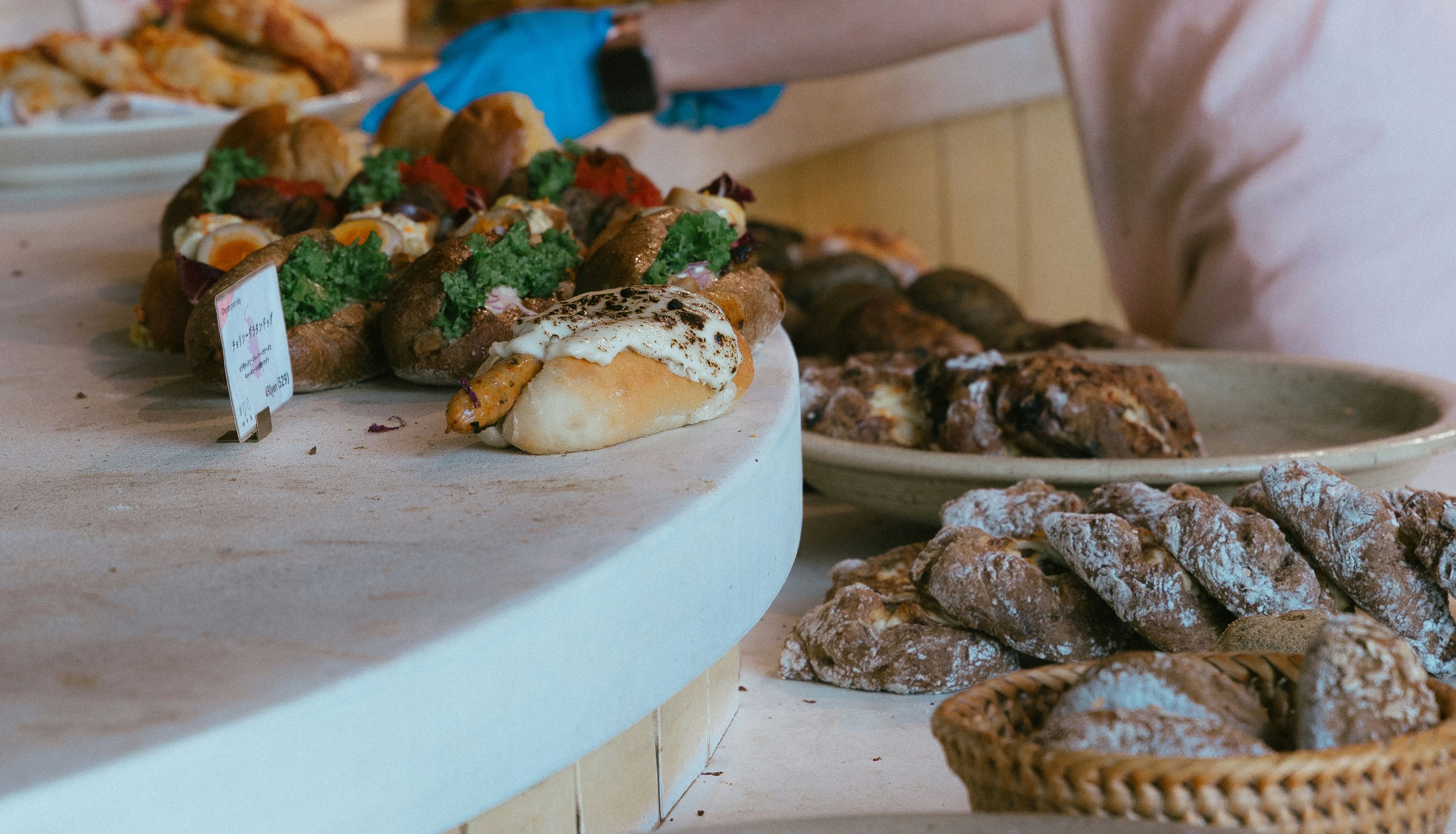 Bakery worker in a cap and apron arranging pastries on a counter