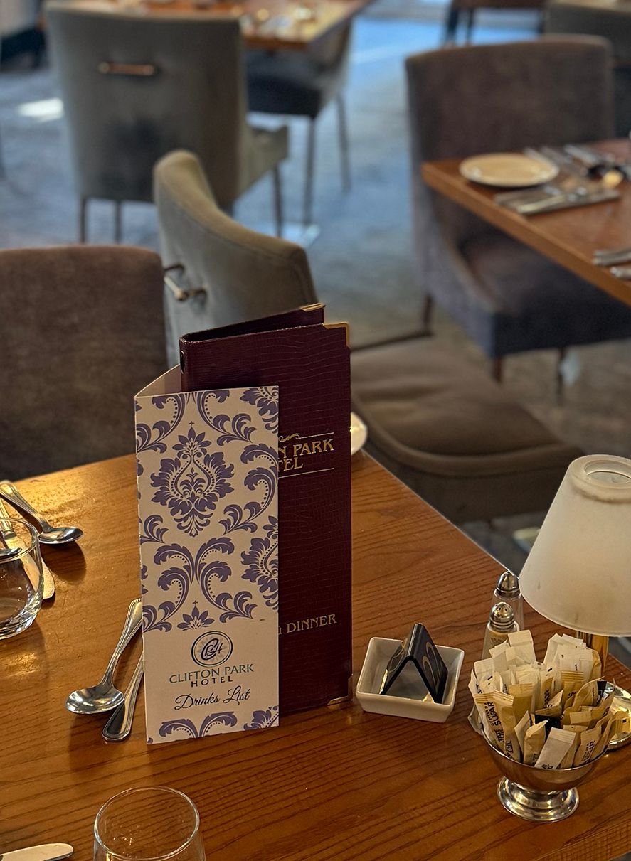 Cosy restaurant dining room with laid tables, menus and chandelier lighting