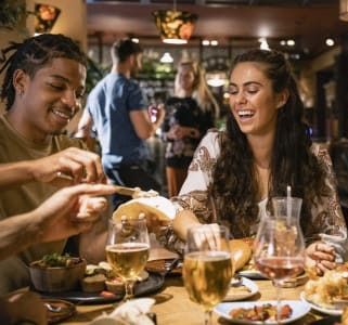Group of friends enjoying dinner and drinks at a restaurant