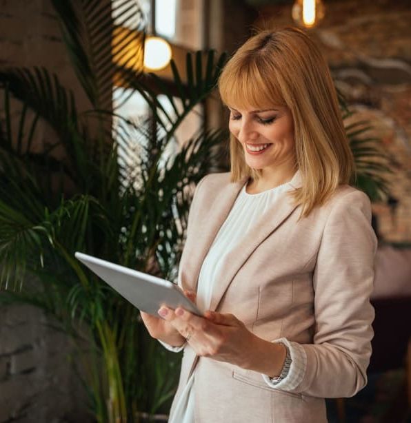 Businesswoman smiling while using a digital tablet indoors