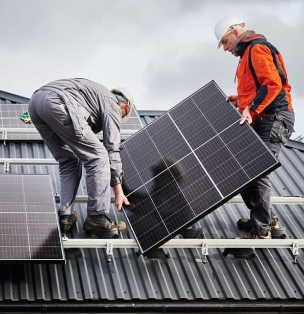 Workers installing solar panels on a rooftop