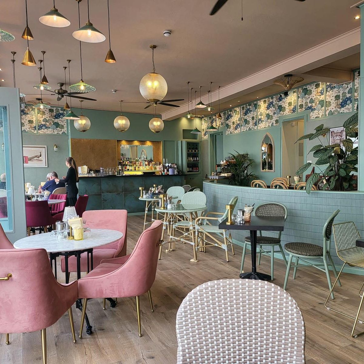 Bright, modern café interior with pastel furniture and decorative lighting.