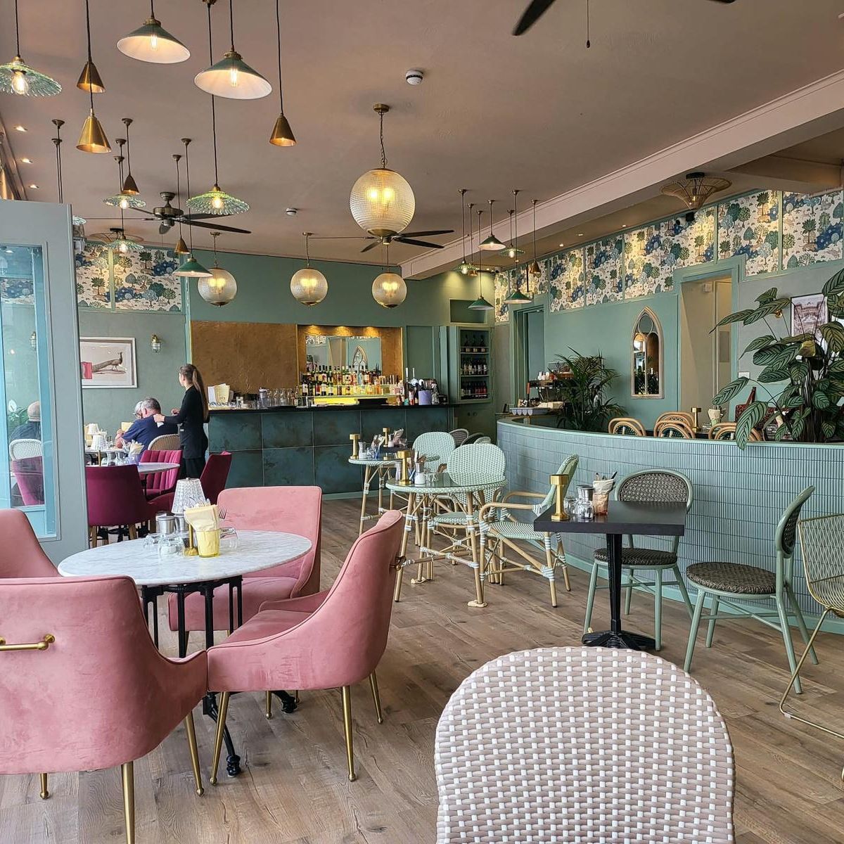 Bright, modern café interior with pastel furniture and decorative lighting.