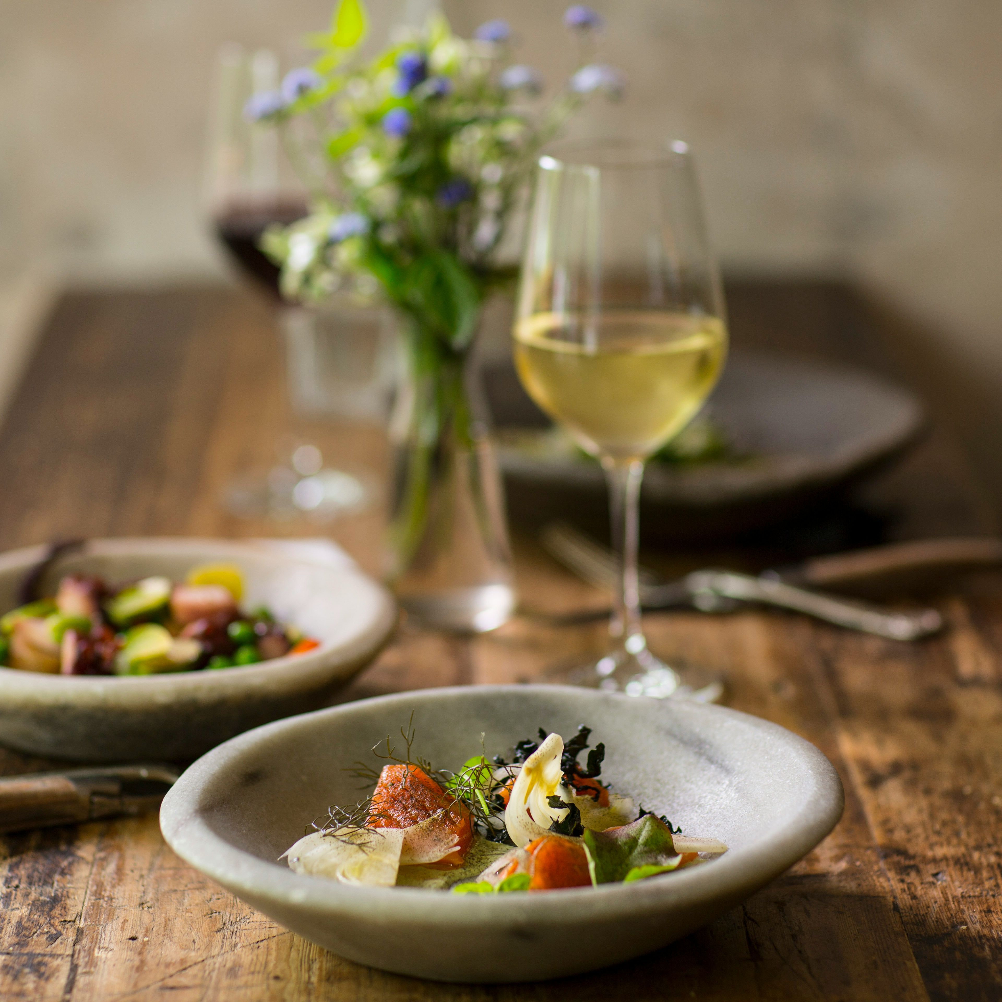 Gourmet meal served with white wine on a rustic wooden table