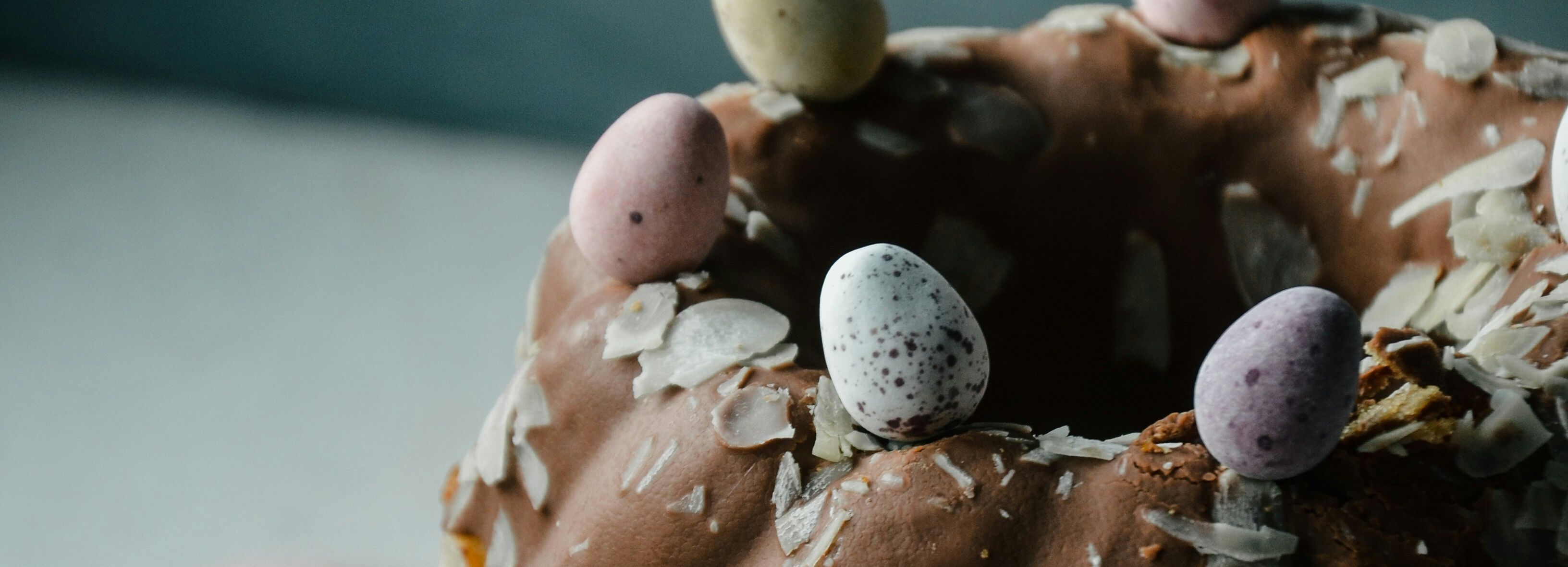 Bundt cake with chocolate icing and decorative mini eggs on top