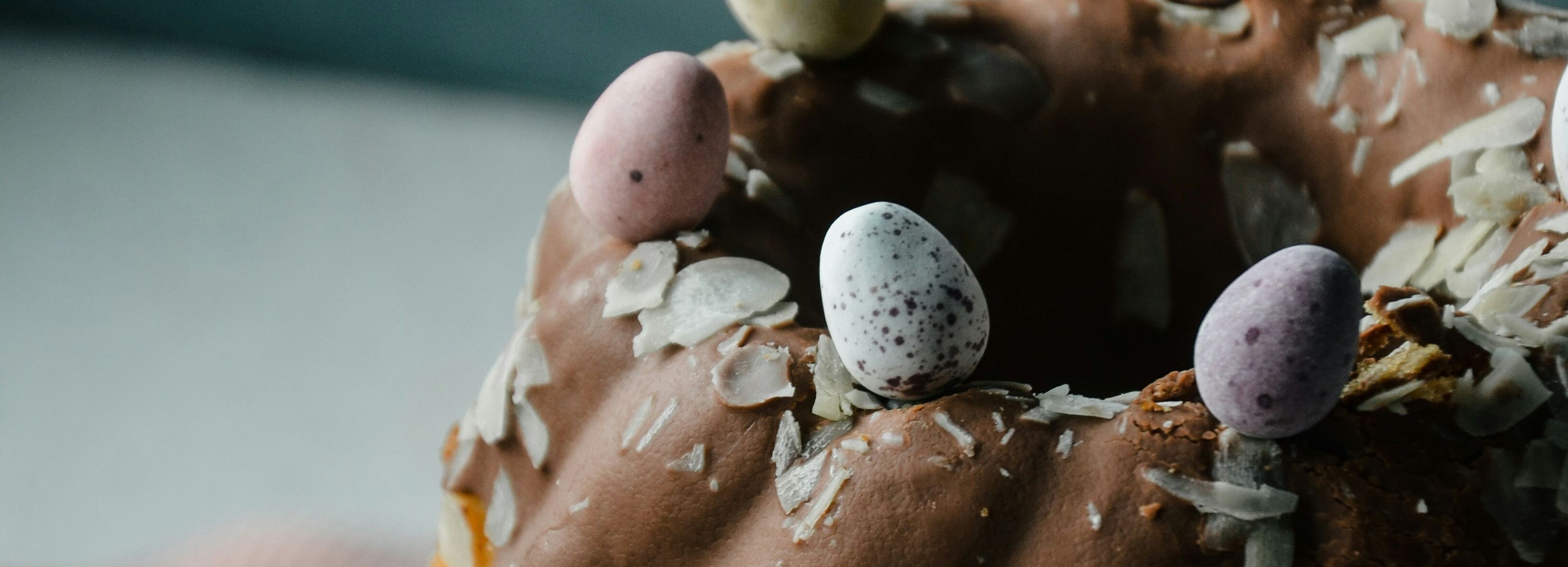 Bundt cake with chocolate icing and decorative mini eggs on top