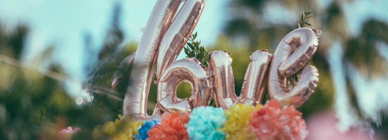Metallic 'love' letter balloons with colorful paper flowers and a decorative radio outdoors