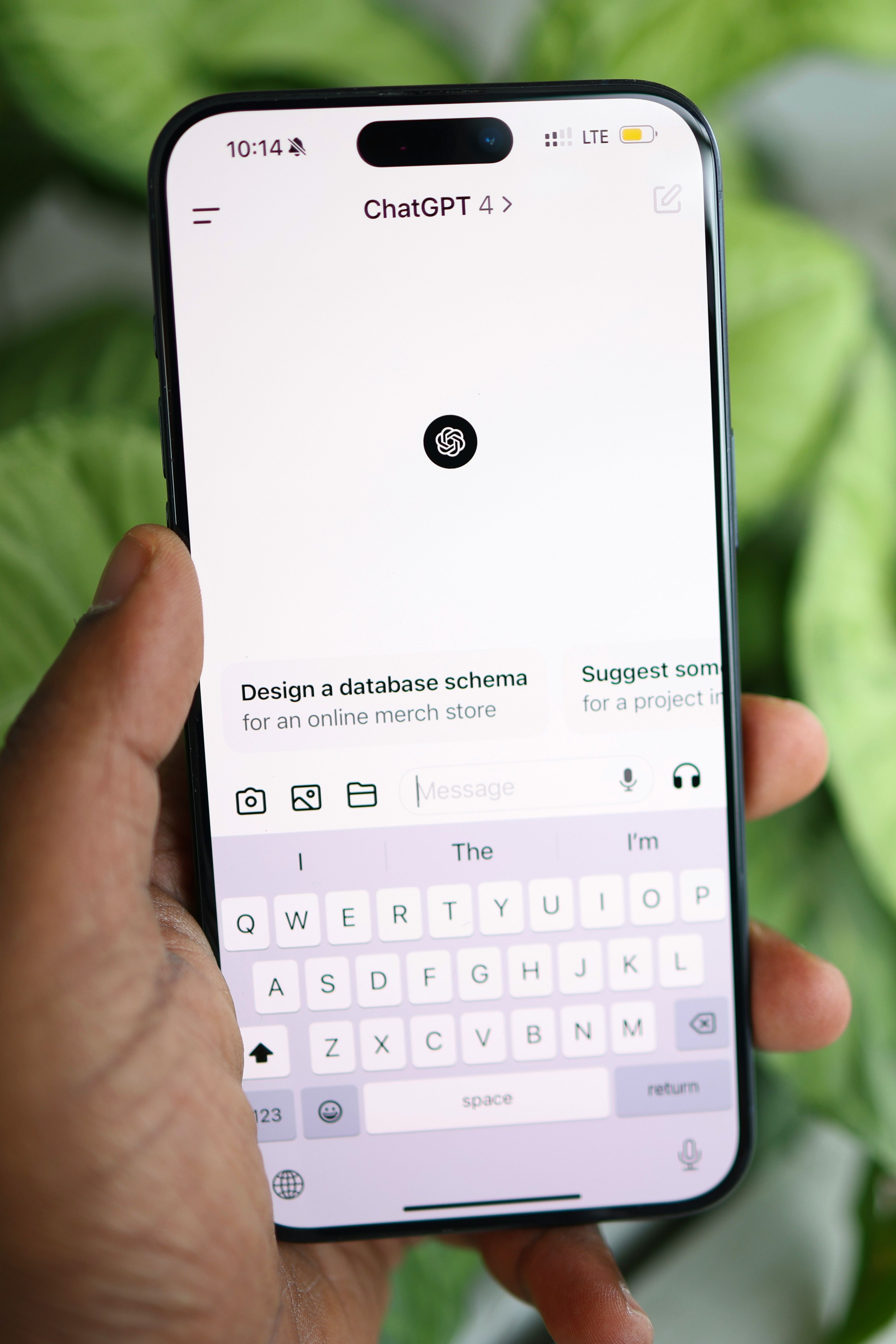 Hand holding a smartphone displaying the ChatGPT app interface