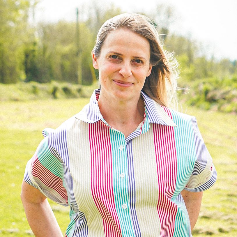 Person standing outdoors wearing a multicolored striped shirt